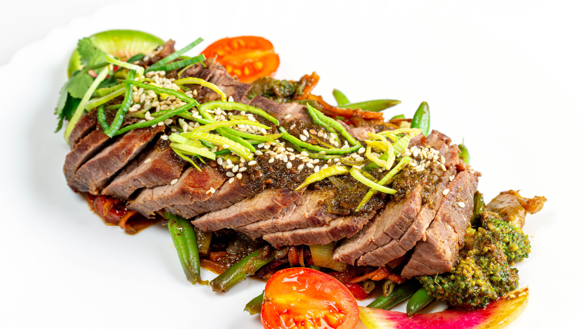 Мясо нарезанное кусочками на белом фоне с овощами