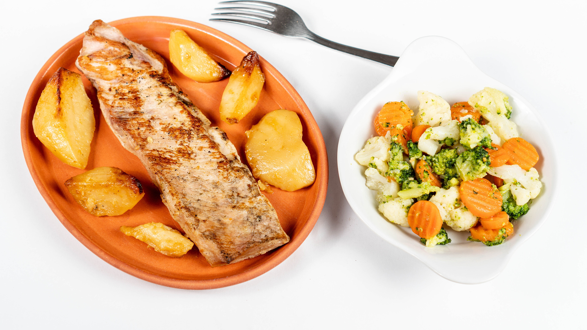 Кусок запеченной рыбы на тарелке с овощами 