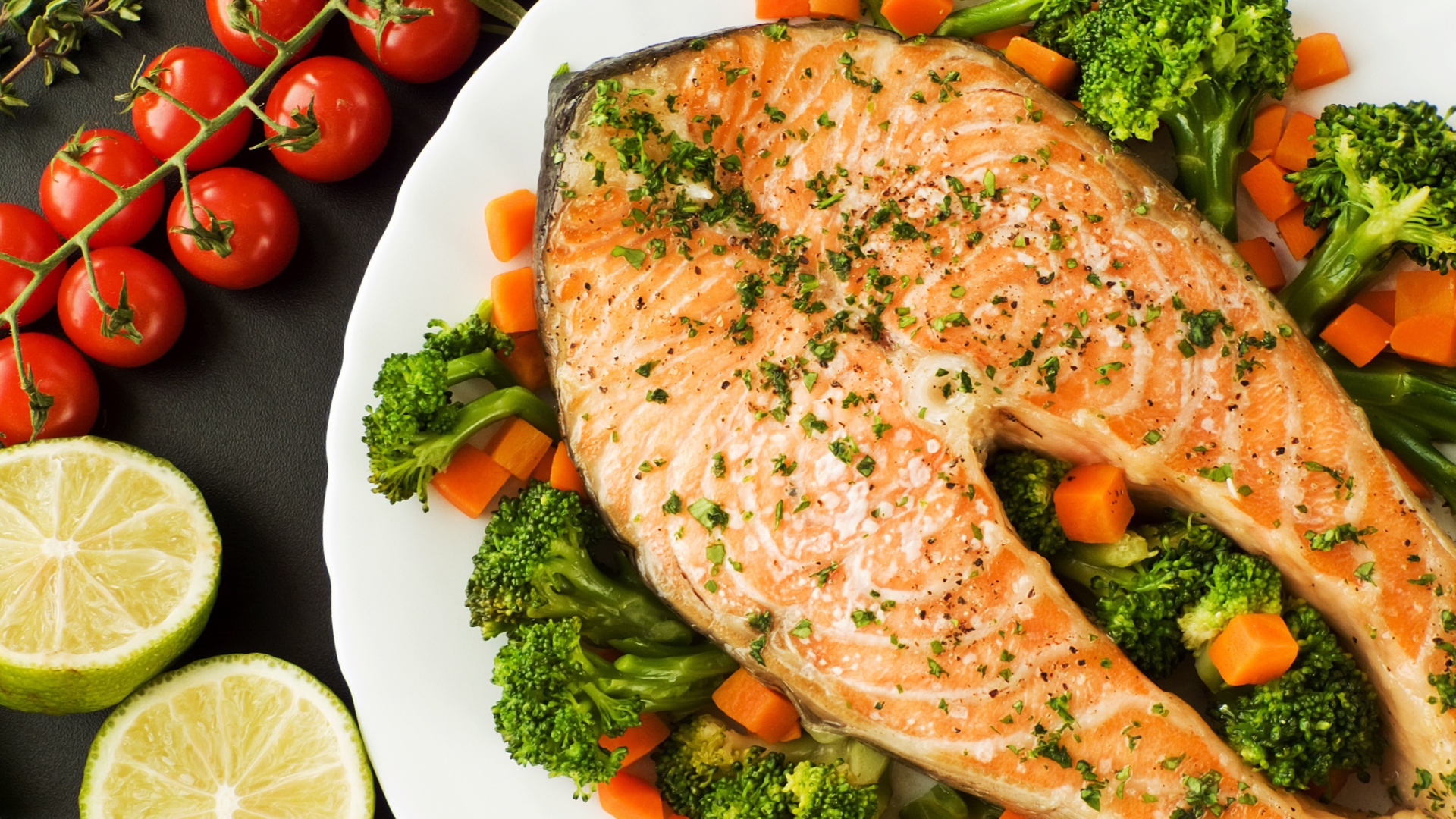 Кусок красной рыбы на тарелке с морковью и брокколи 