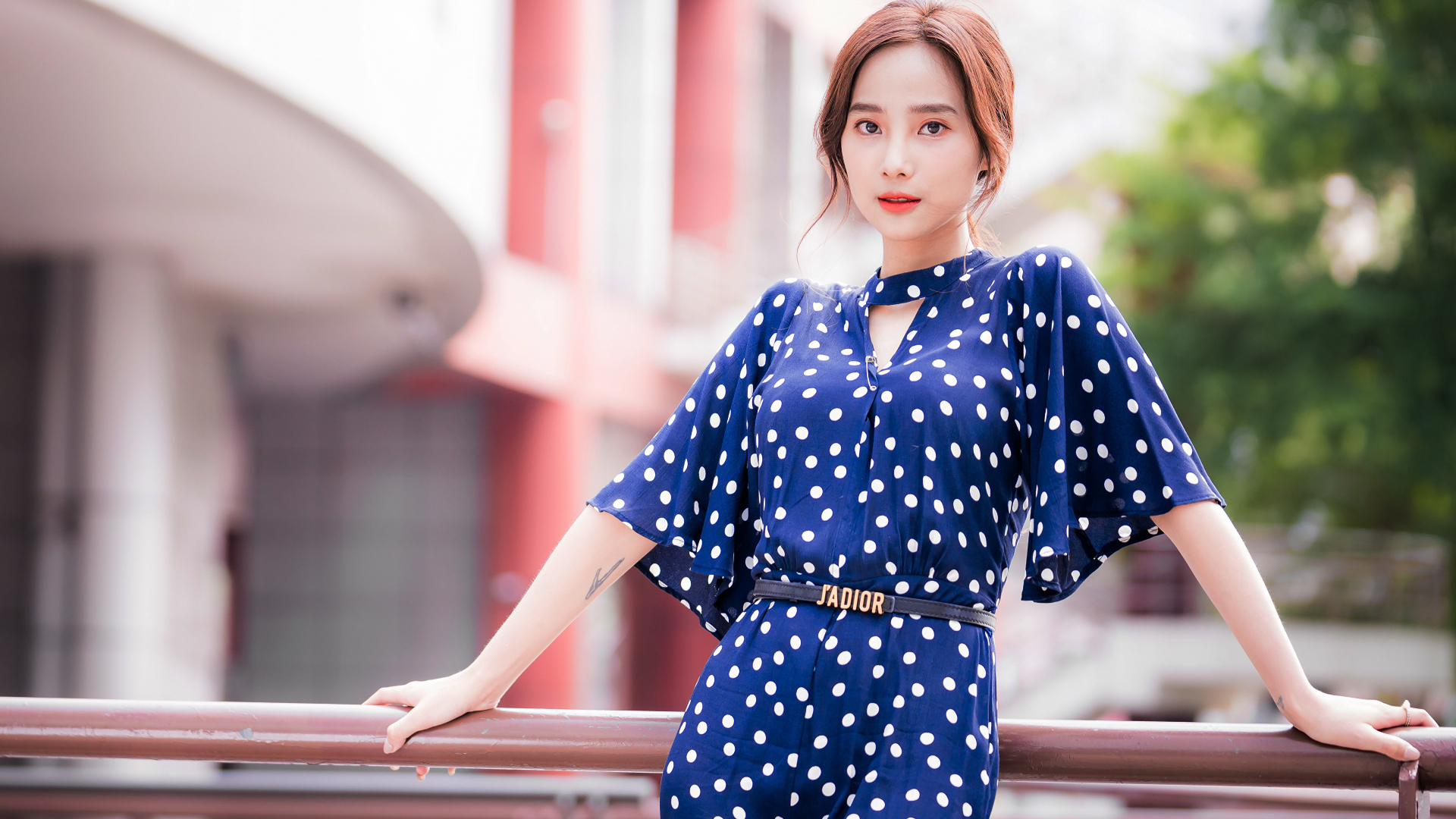 Девушка азиатка в синем платье в белый горошек