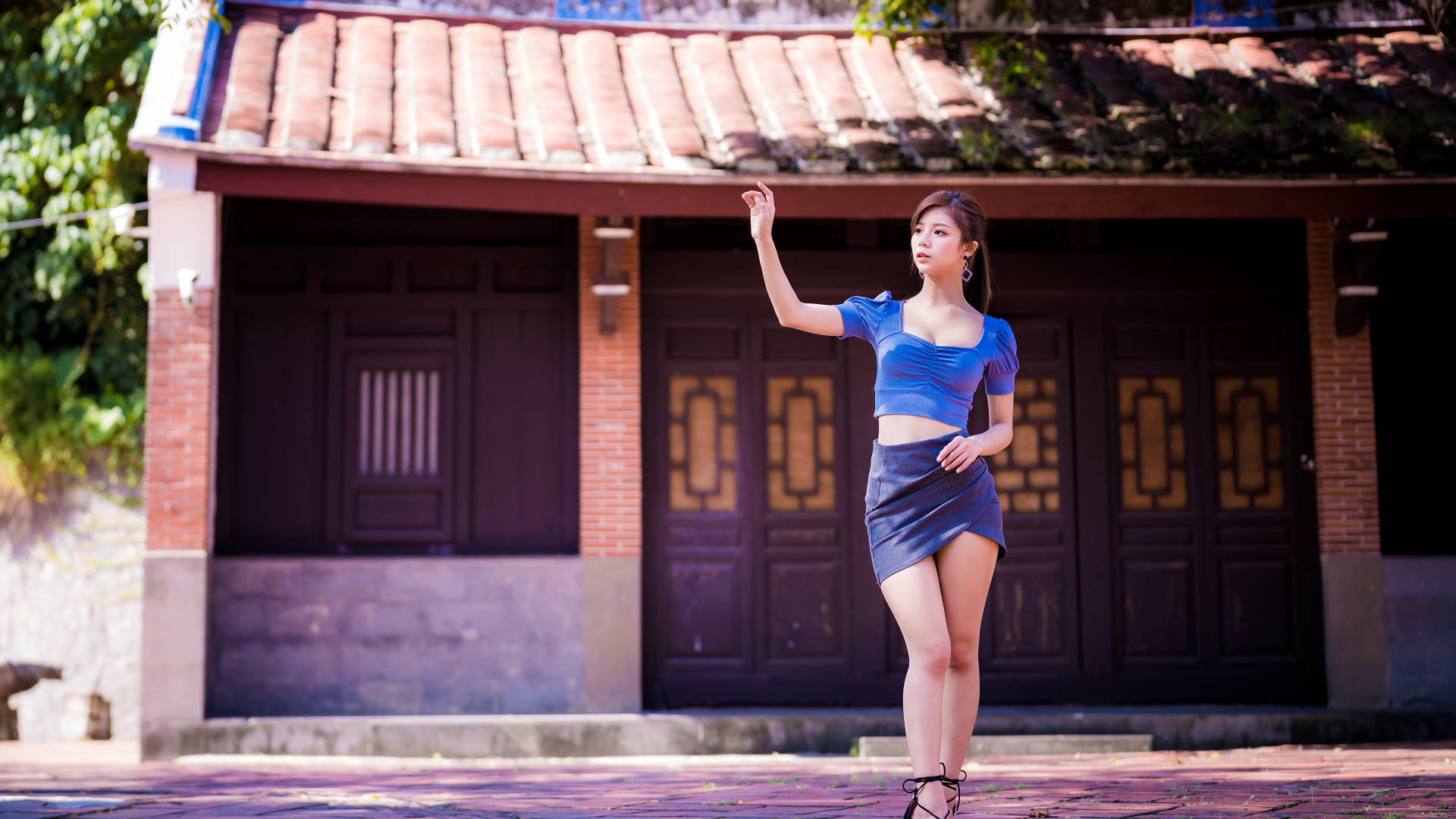 Девушка азиатка в короткой юбке у здания 