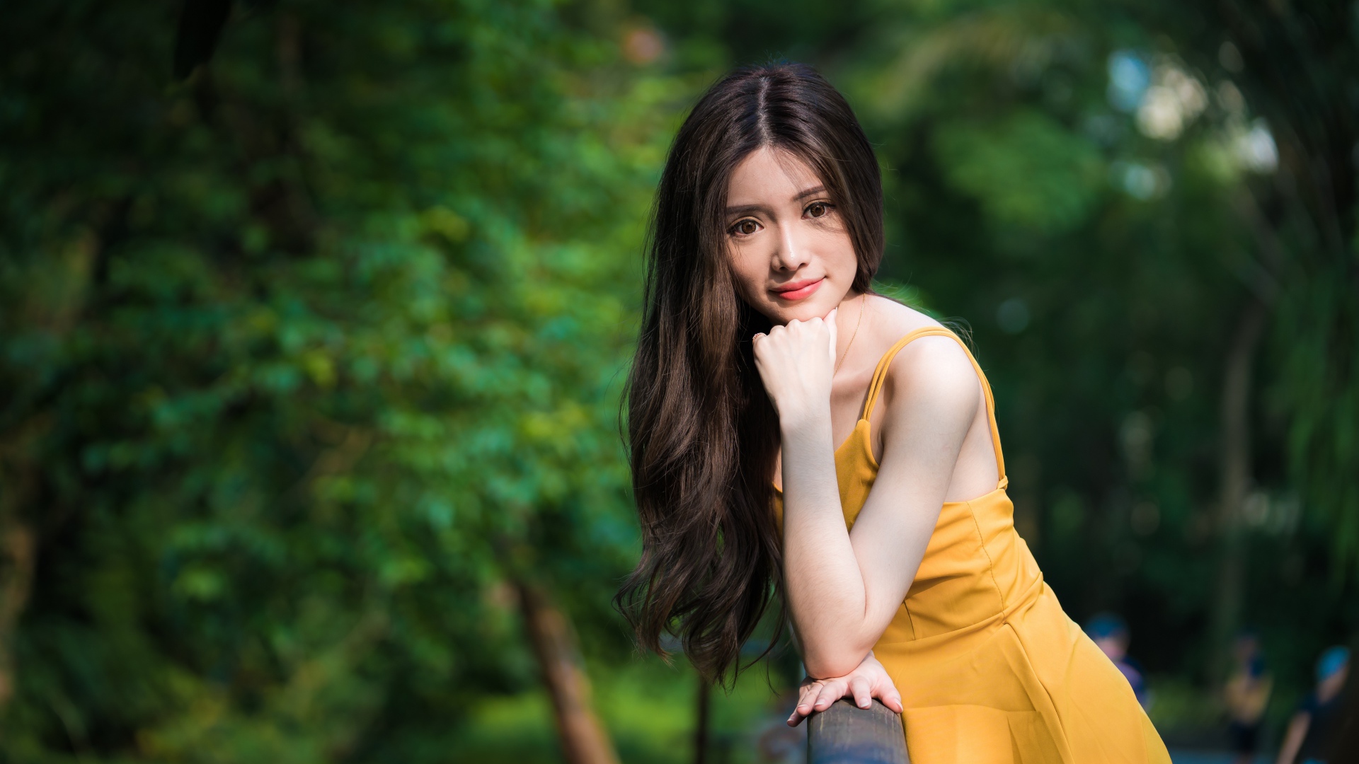 Девушка азиатка с большими карими глазами в желтом платье 