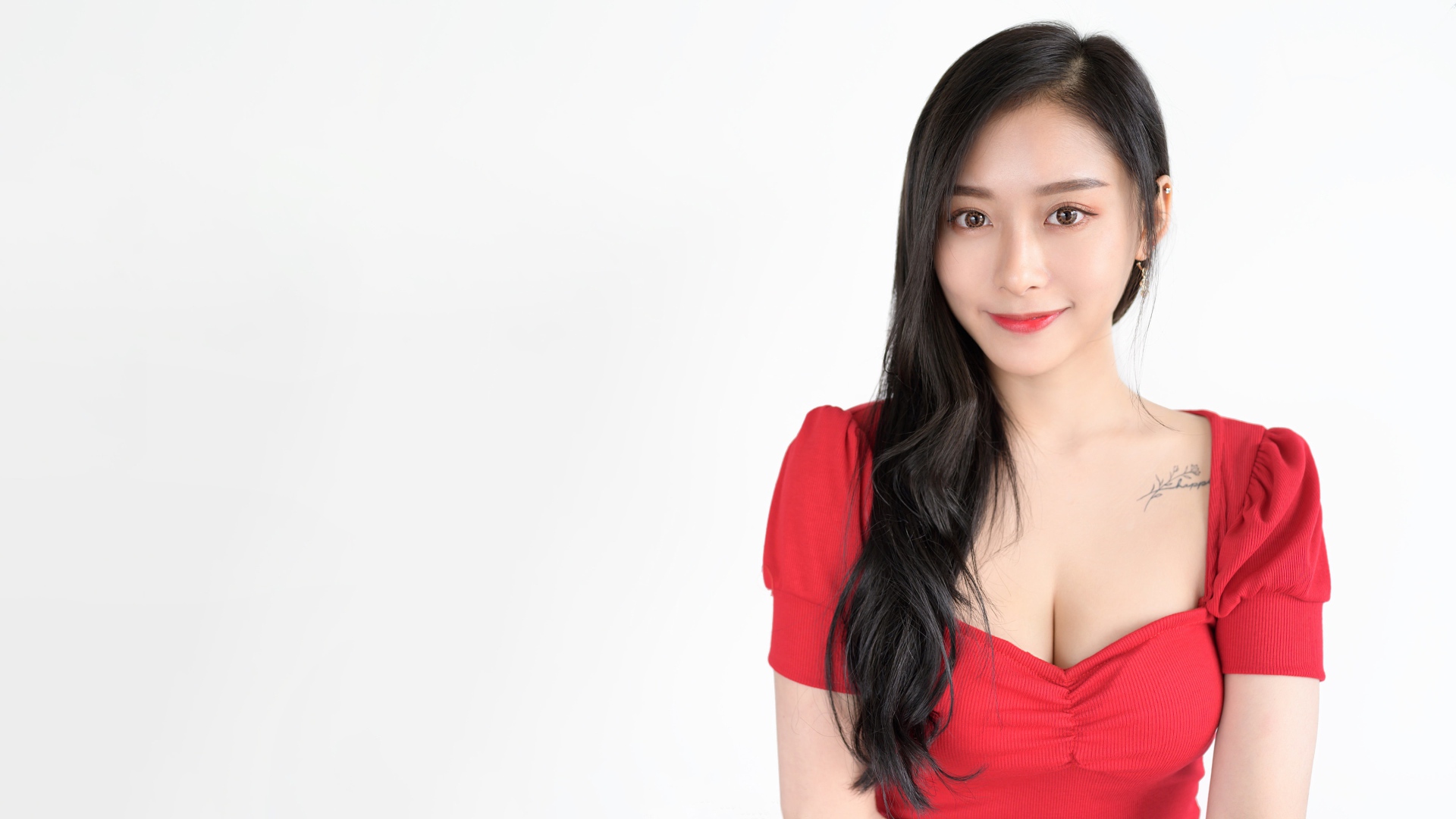 Красивая девушка азиатка в красном платье на белом фоне