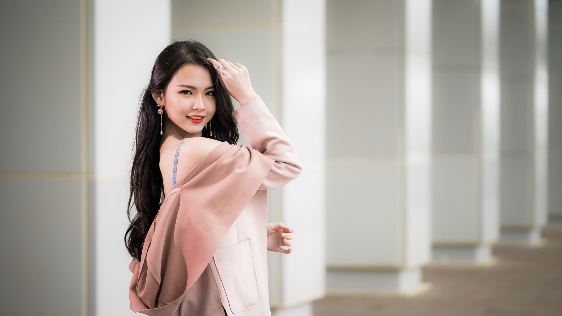 Красивая девушка азиатка с длинными волосами в розовом пальто 