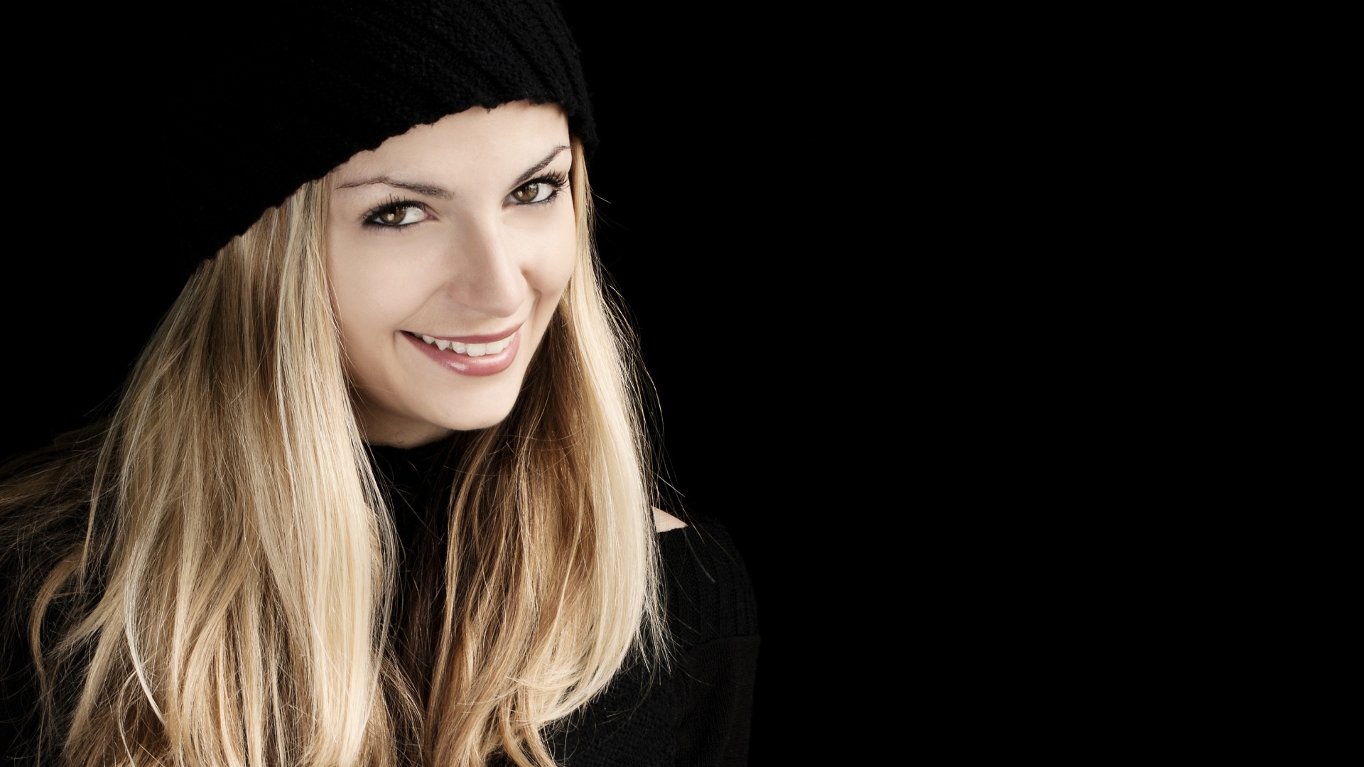 Красивая блондинка в шапке на черном фоне