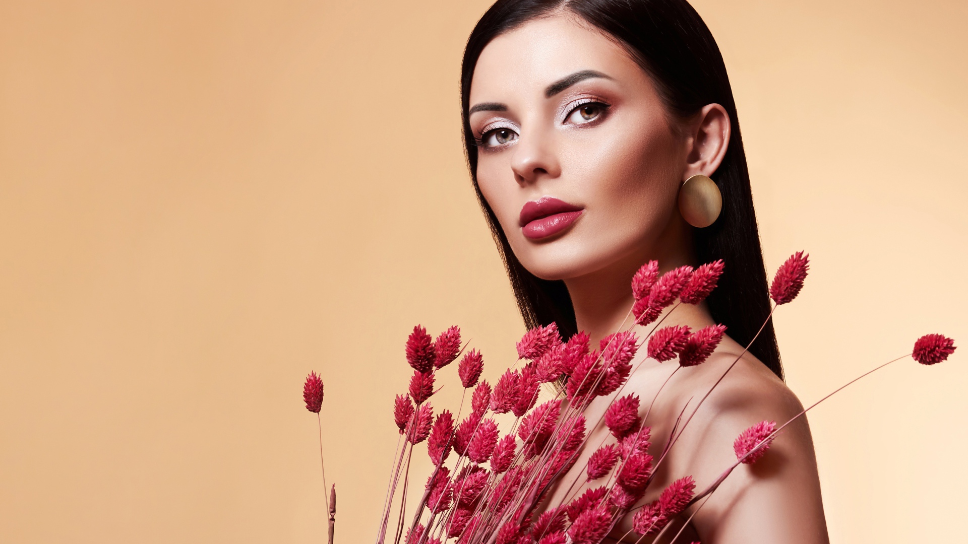 Красивая брюнетка в букетом красных цветов 