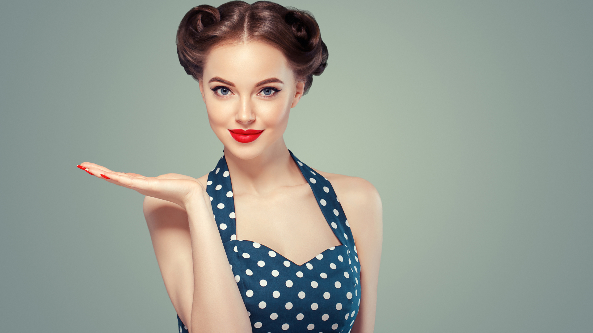 Красивая девушка в платье в горошек на сером фоне