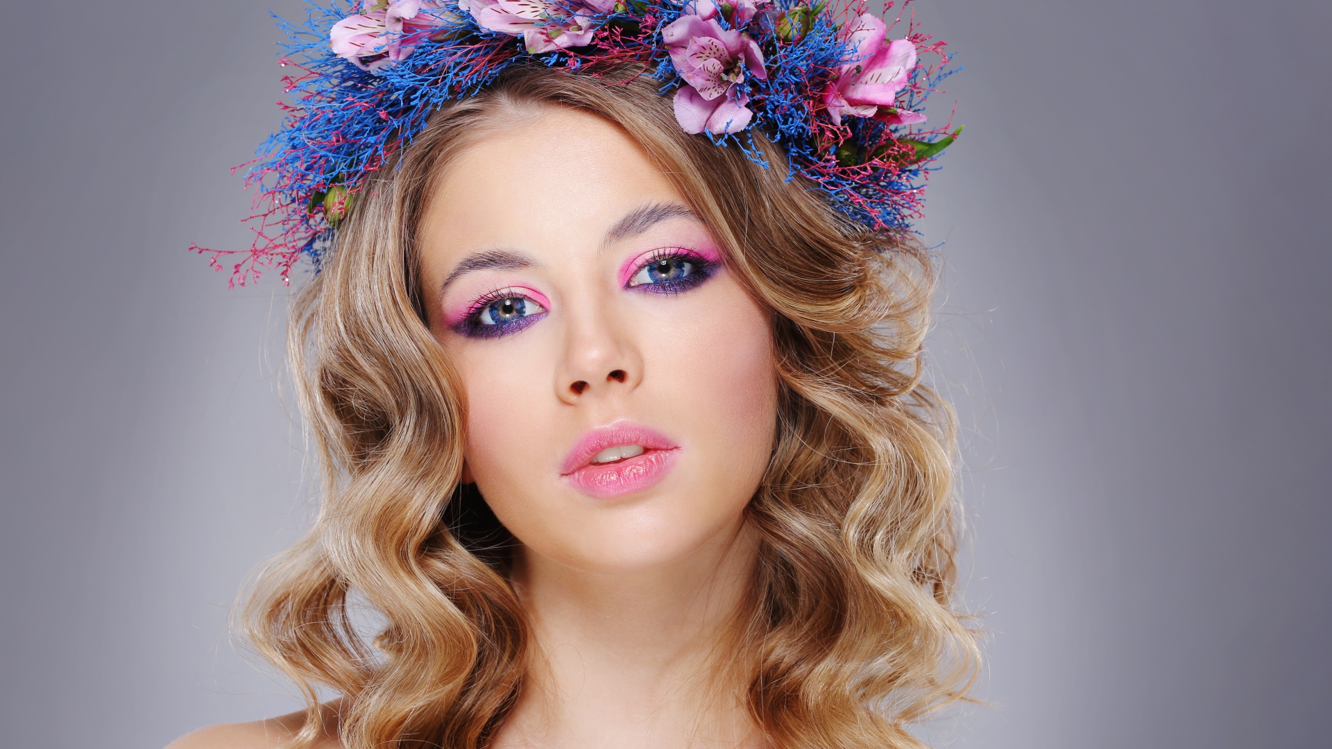 Красивая девушка с нежным макияжем с венком на голове на сером фоне
