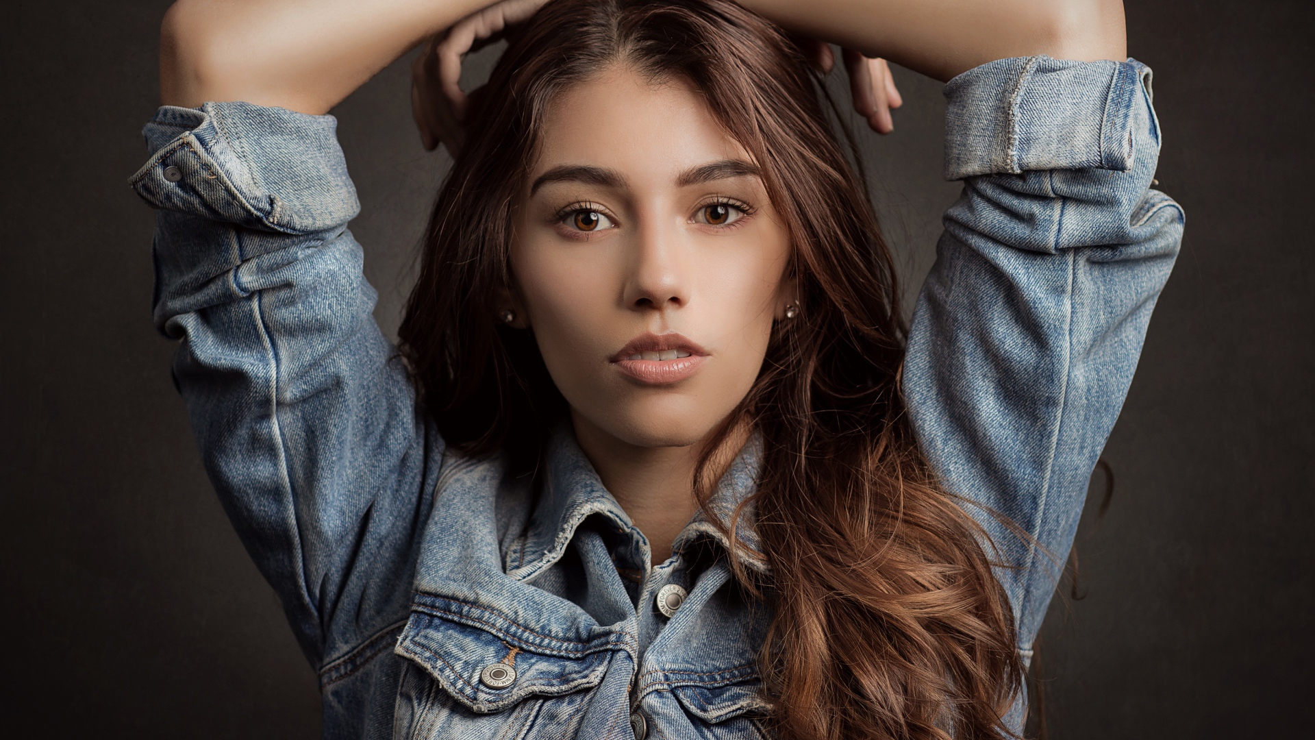 Красивая длинноволосая шатенка в джинсовой куртке 