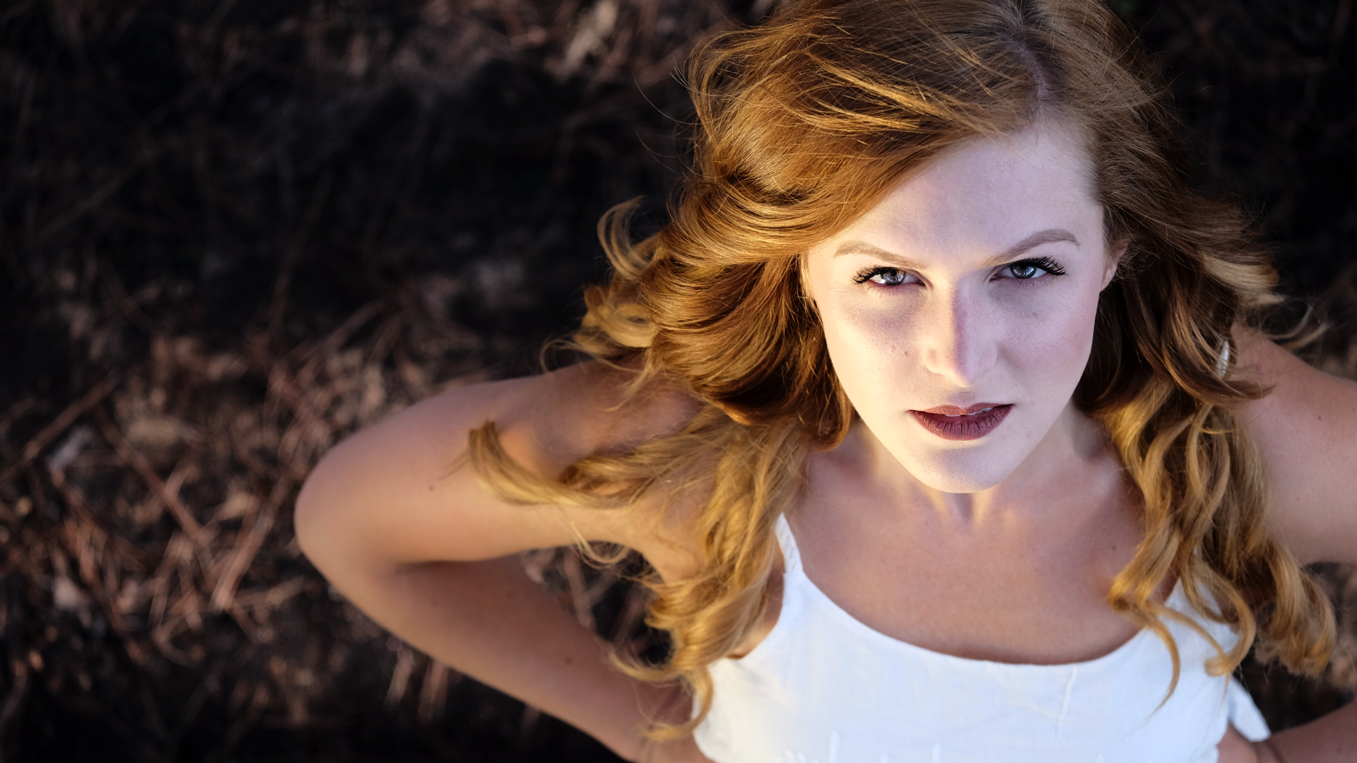 Красивый взгляд рыжеволосой девушки в белом платье