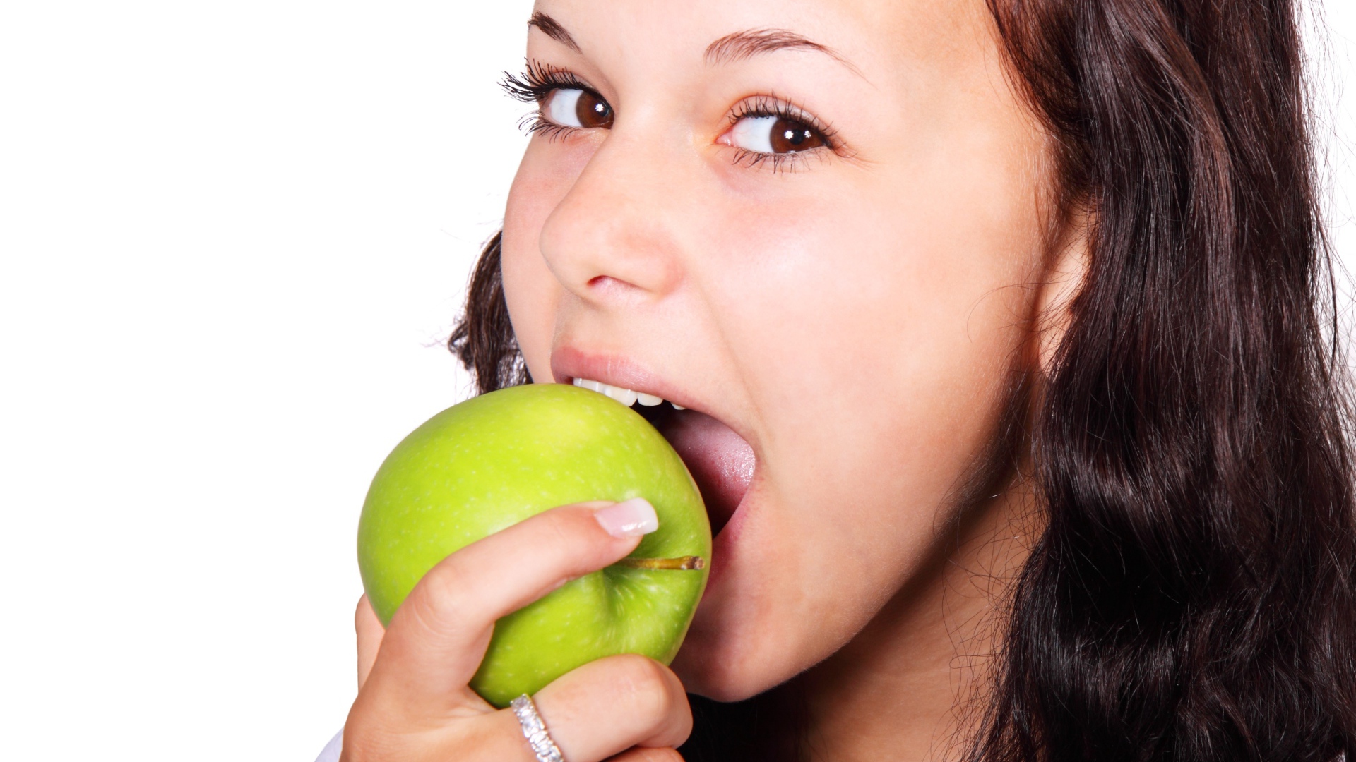 Brown-eyed girl eating a green apple