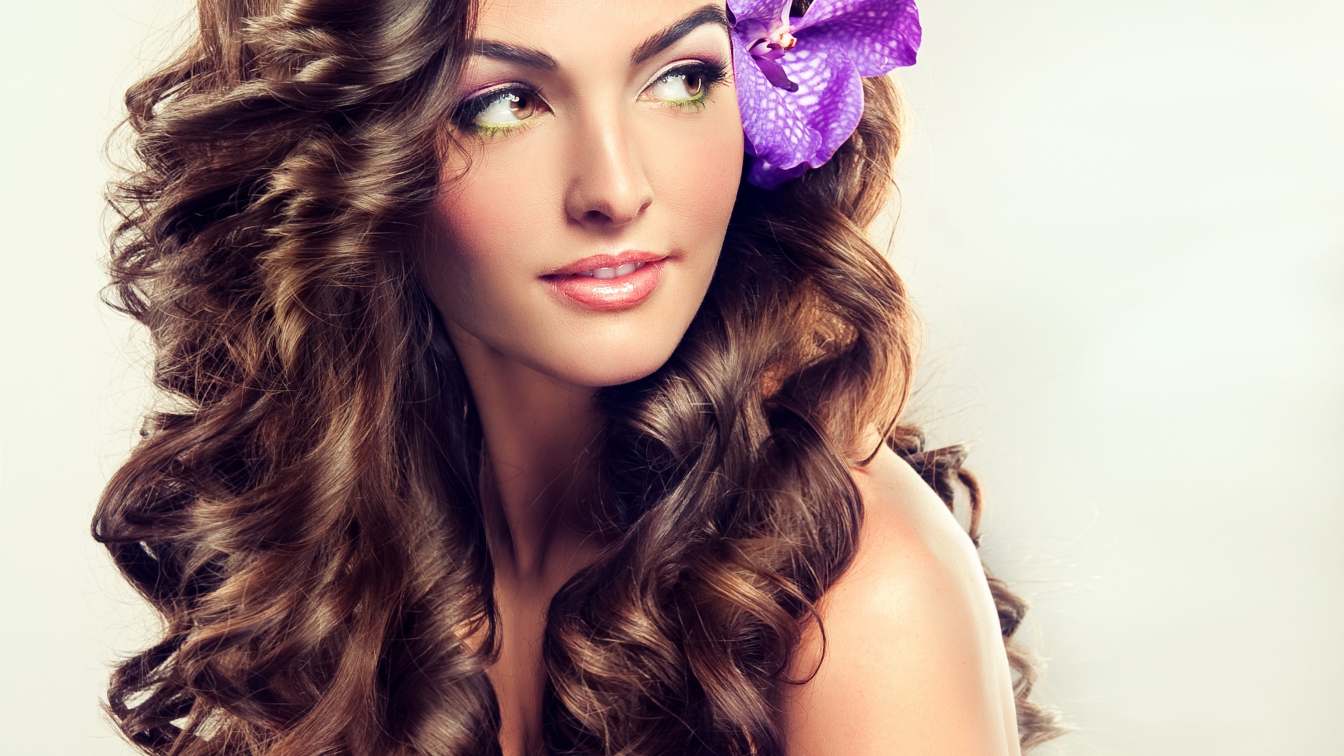 Цветок в красивых длинных волосах молодой девушки