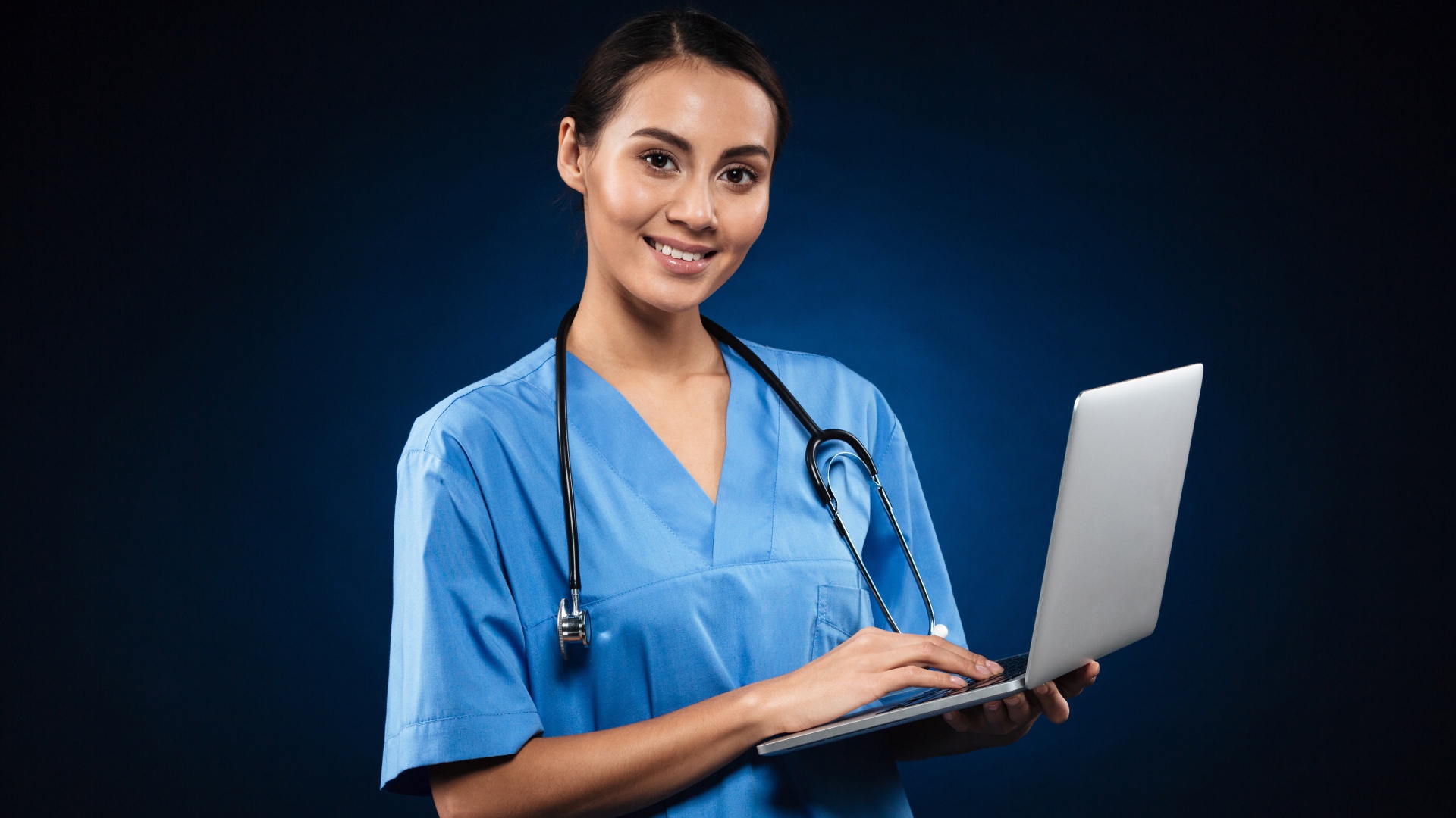 Девушка врач с ноутбуком на синем фоне 