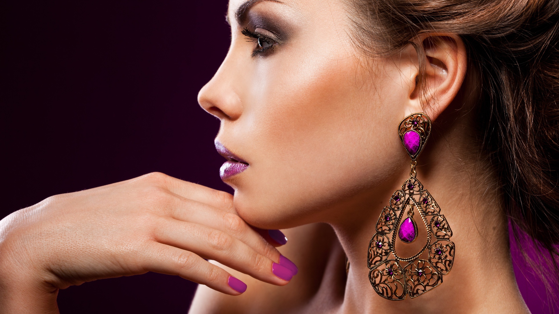Лицо девушки с красивым макияжем и дорогими серьгами