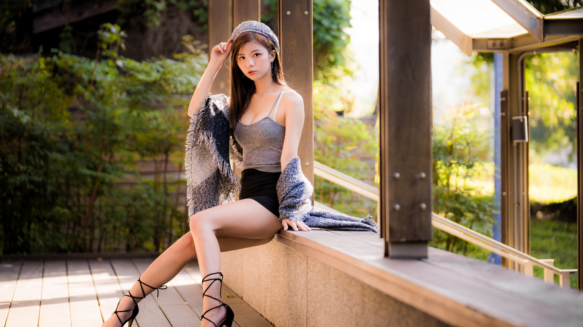 Длинноногая азиатка сидит на окне 