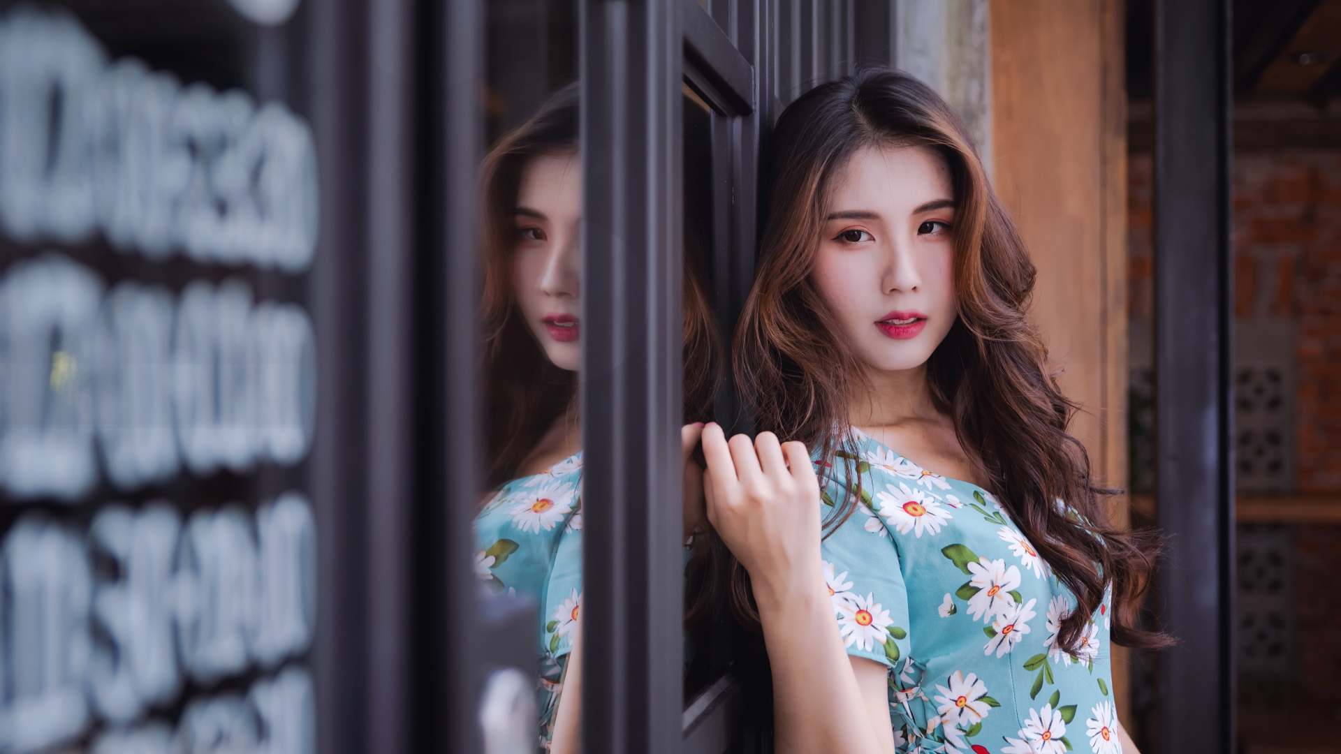 Длинноволосая девушка азиатка стоит у окна