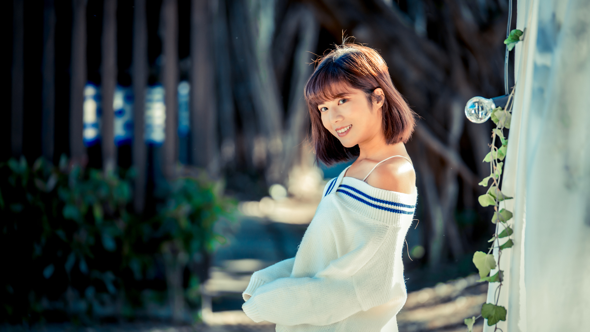 Улыбающаяся девушка азиатка в белом свитере 