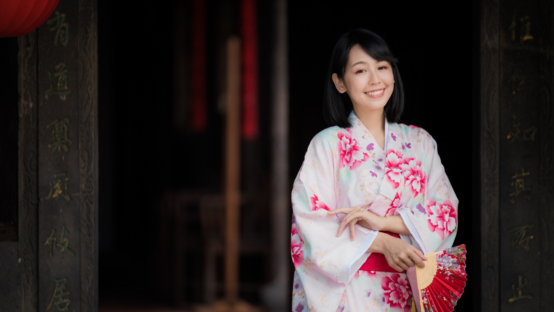 Улыбающаяся девушка азиатка в кимоно с веером в руке