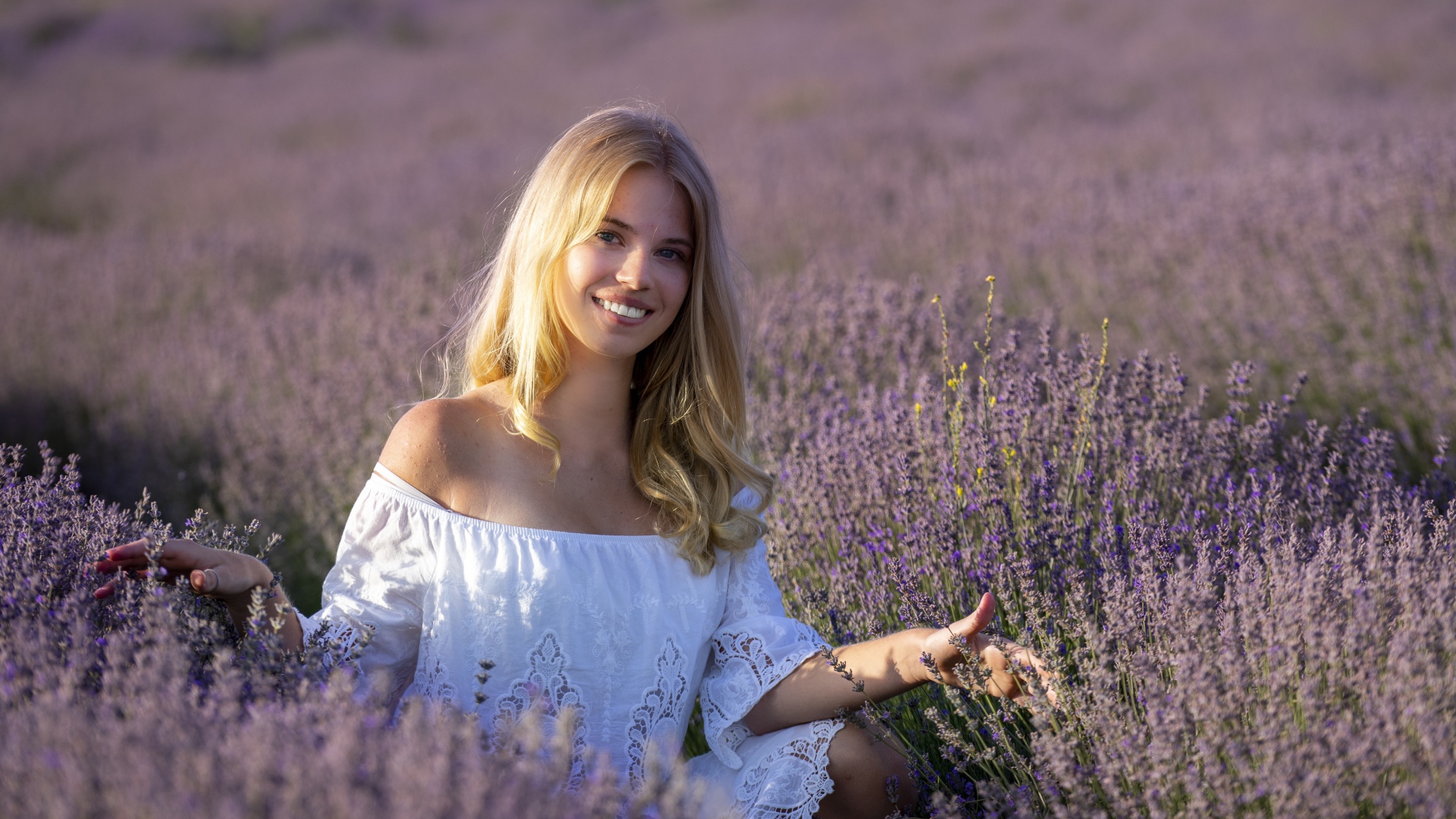 Улыбающаяся девушка в белом платье на лавандовом поле 