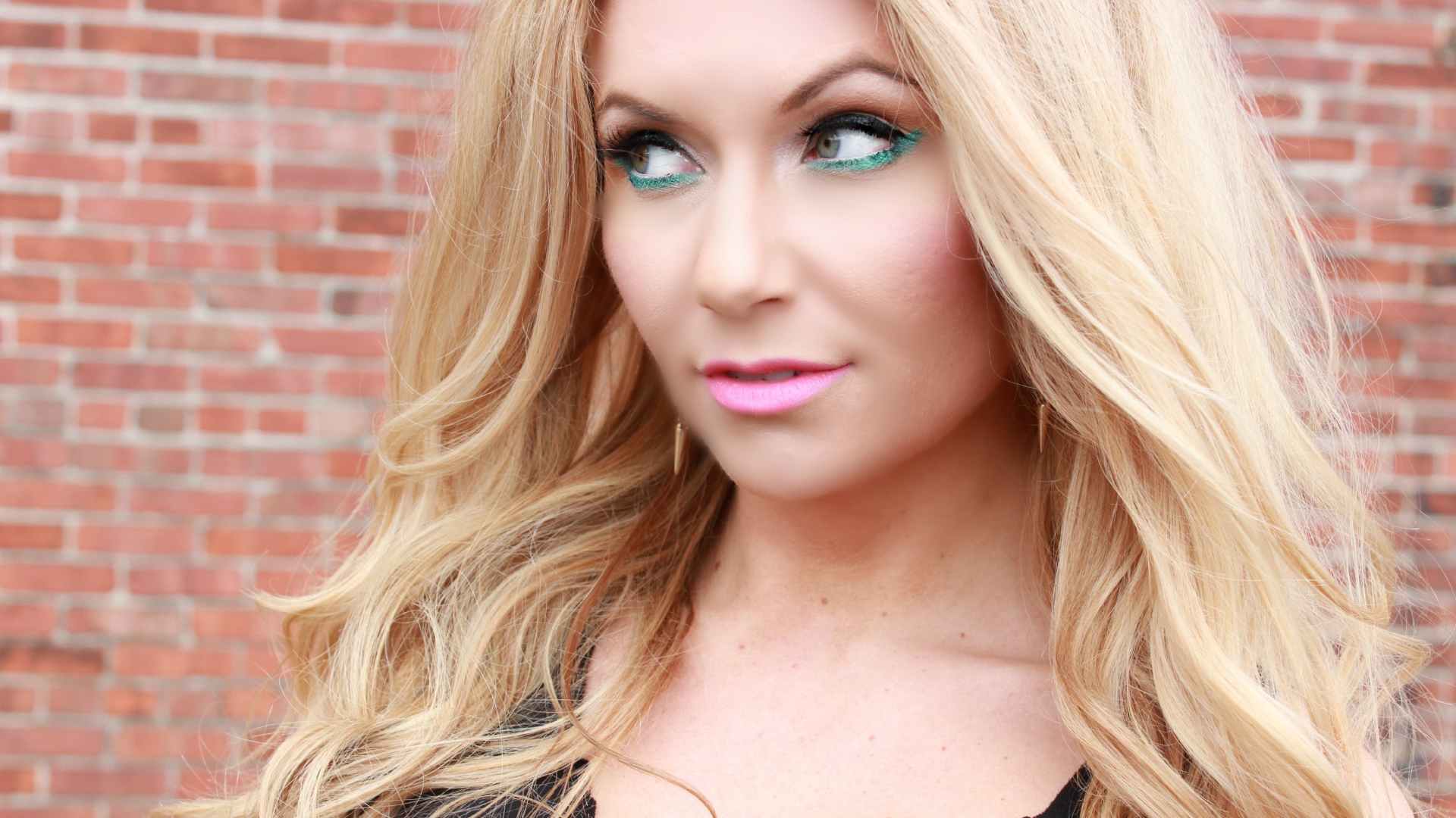 Эффектная длинноволосая блондинка у стены 
