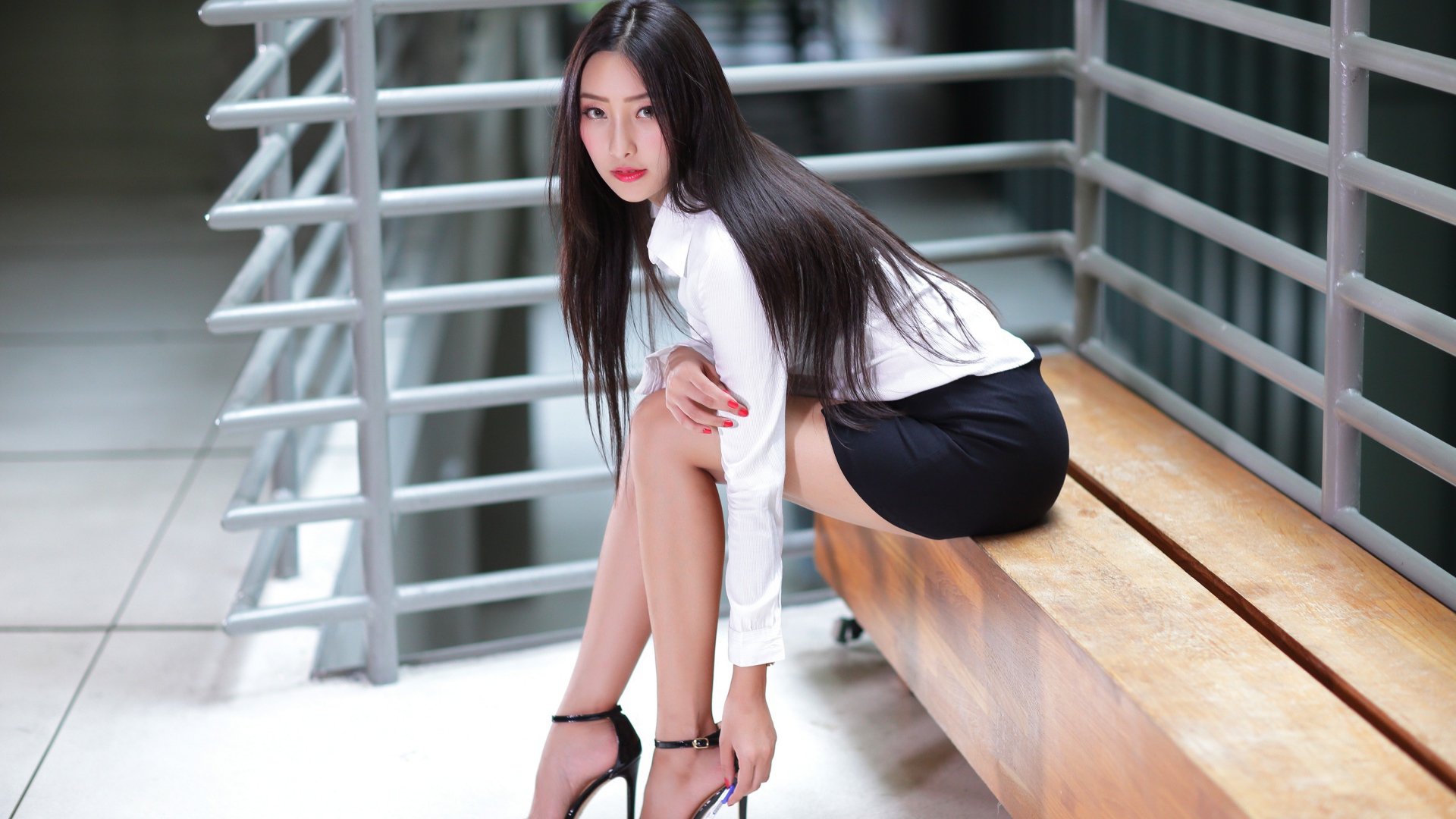 Стильная деловая девушка азиатка сидит  на лавке