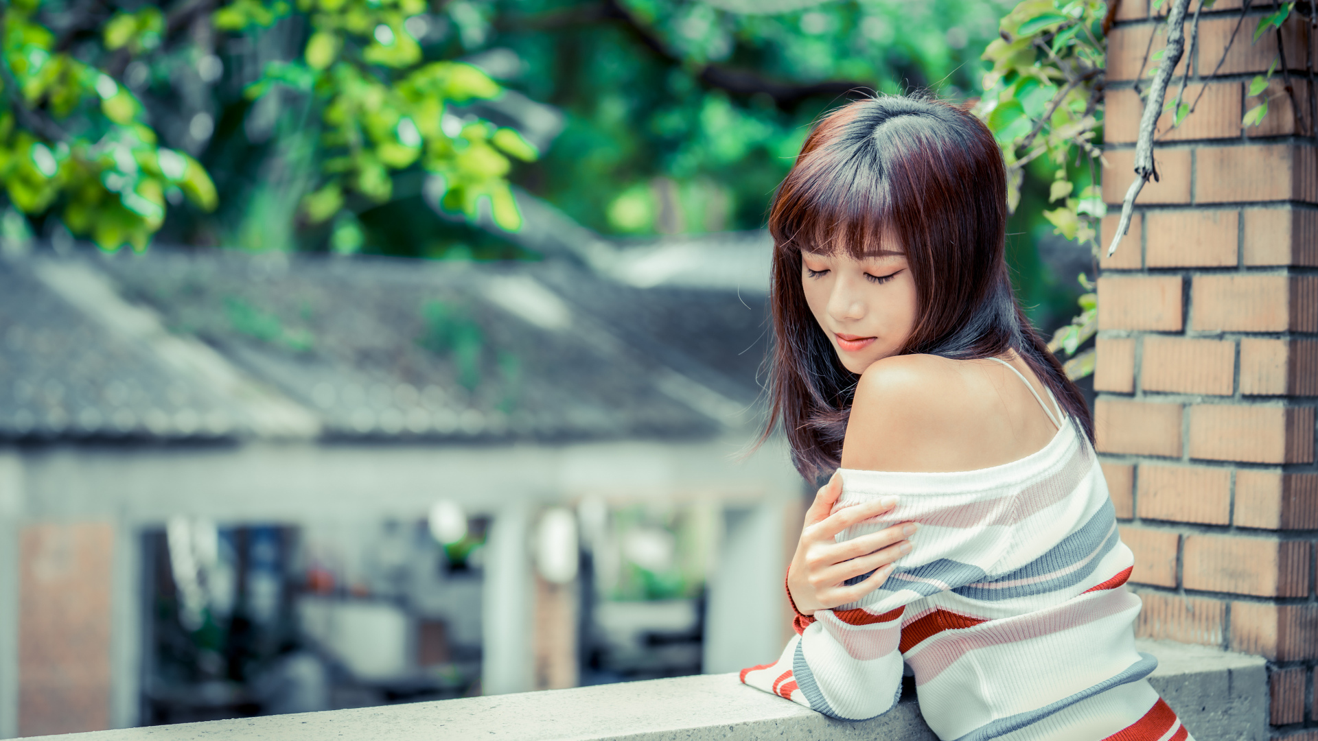 Нежная азиатка стоит на балконе