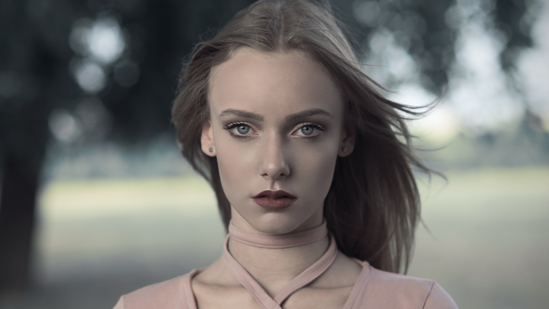 Ветер развивает волосы красивой голубоглазой девушки