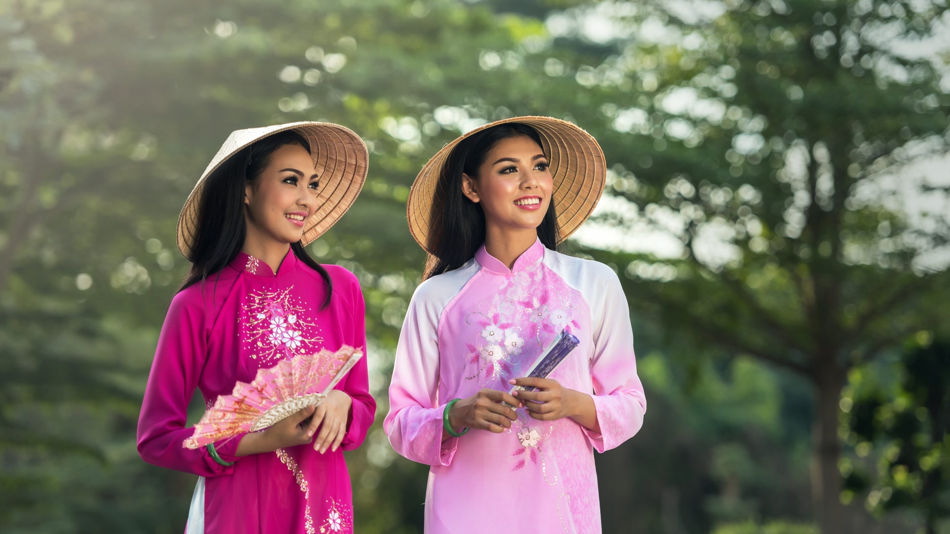 Две девушки азиатки в платьях с веером в руках