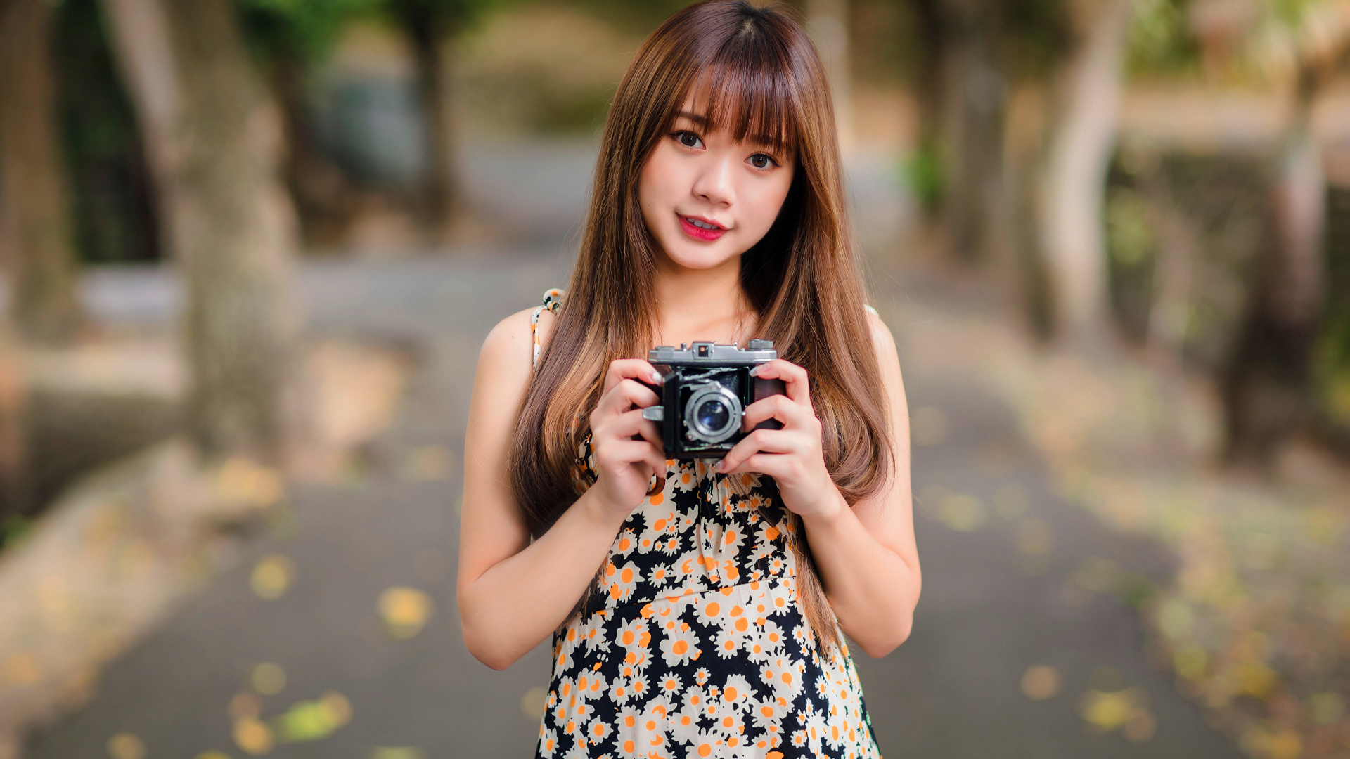 Молодая девушка азиатка с фотоаппаратом в руках 