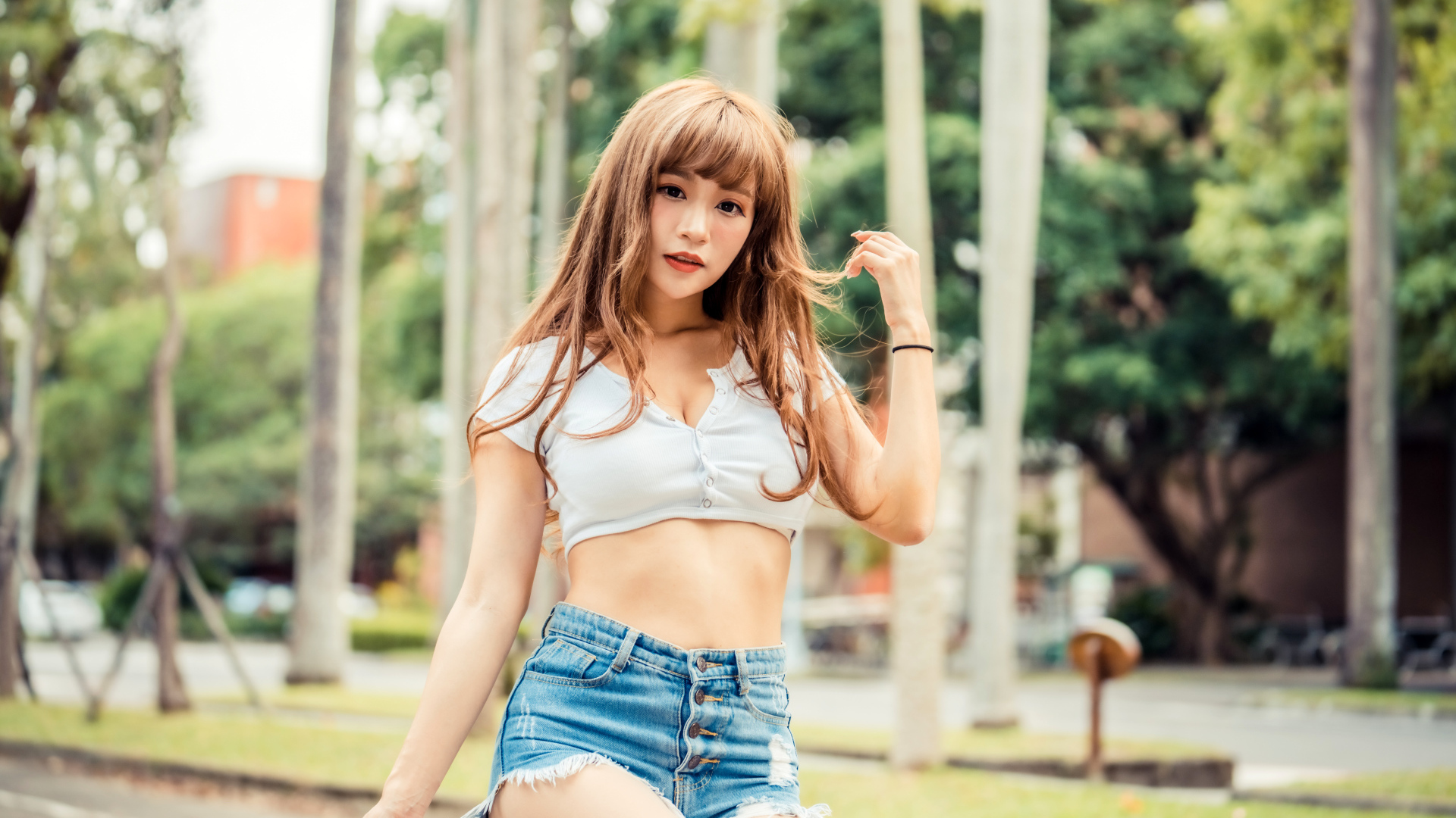 Молодая азиатка в коротком топе и синих шортах 