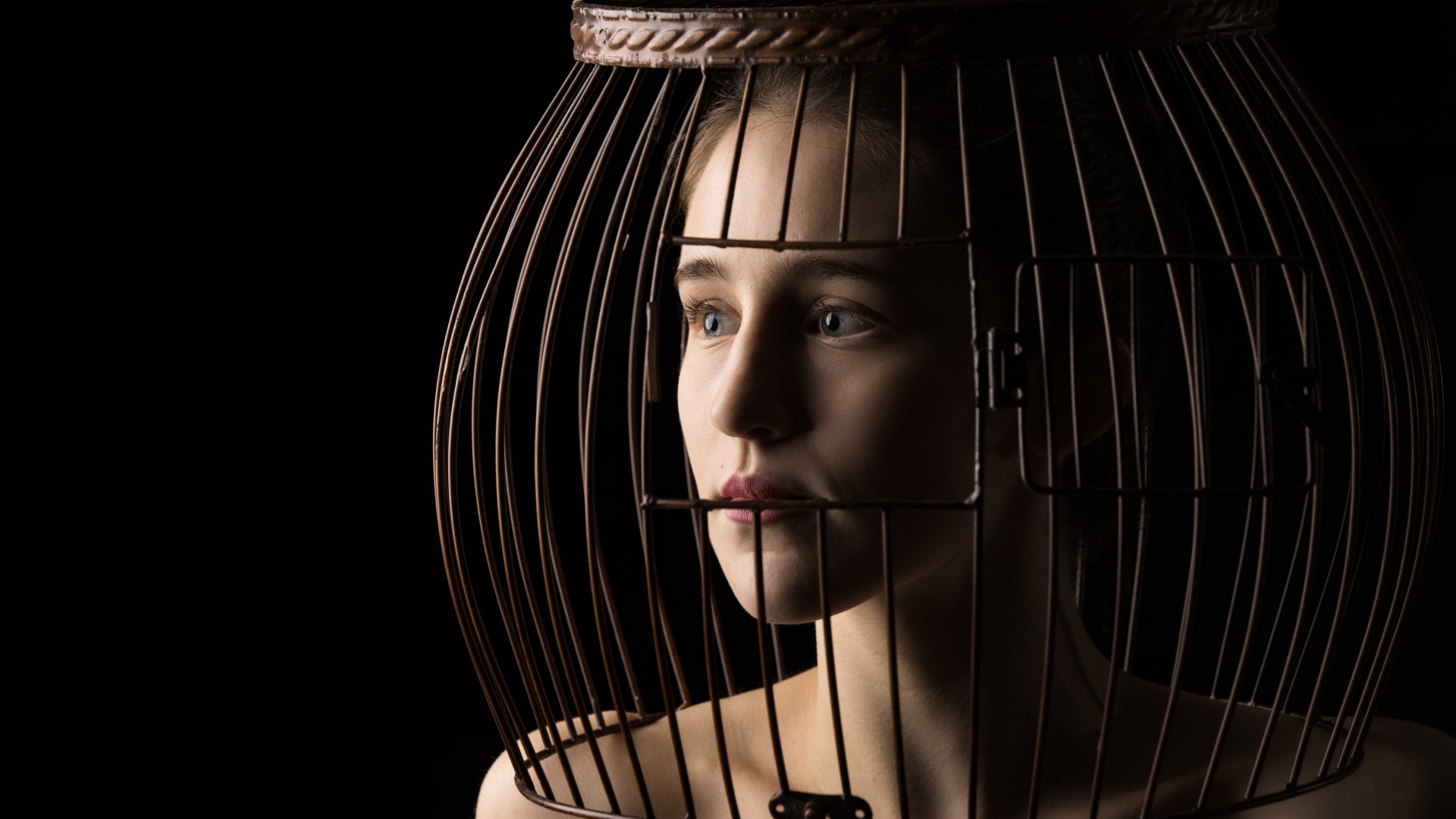 Молодая девушка с клеткой на голове 