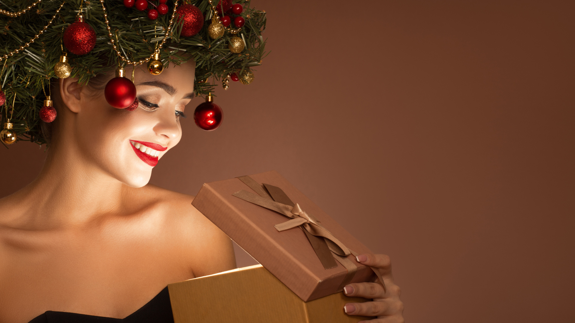 Красивая девушка с рождественским венком на голове с подарком