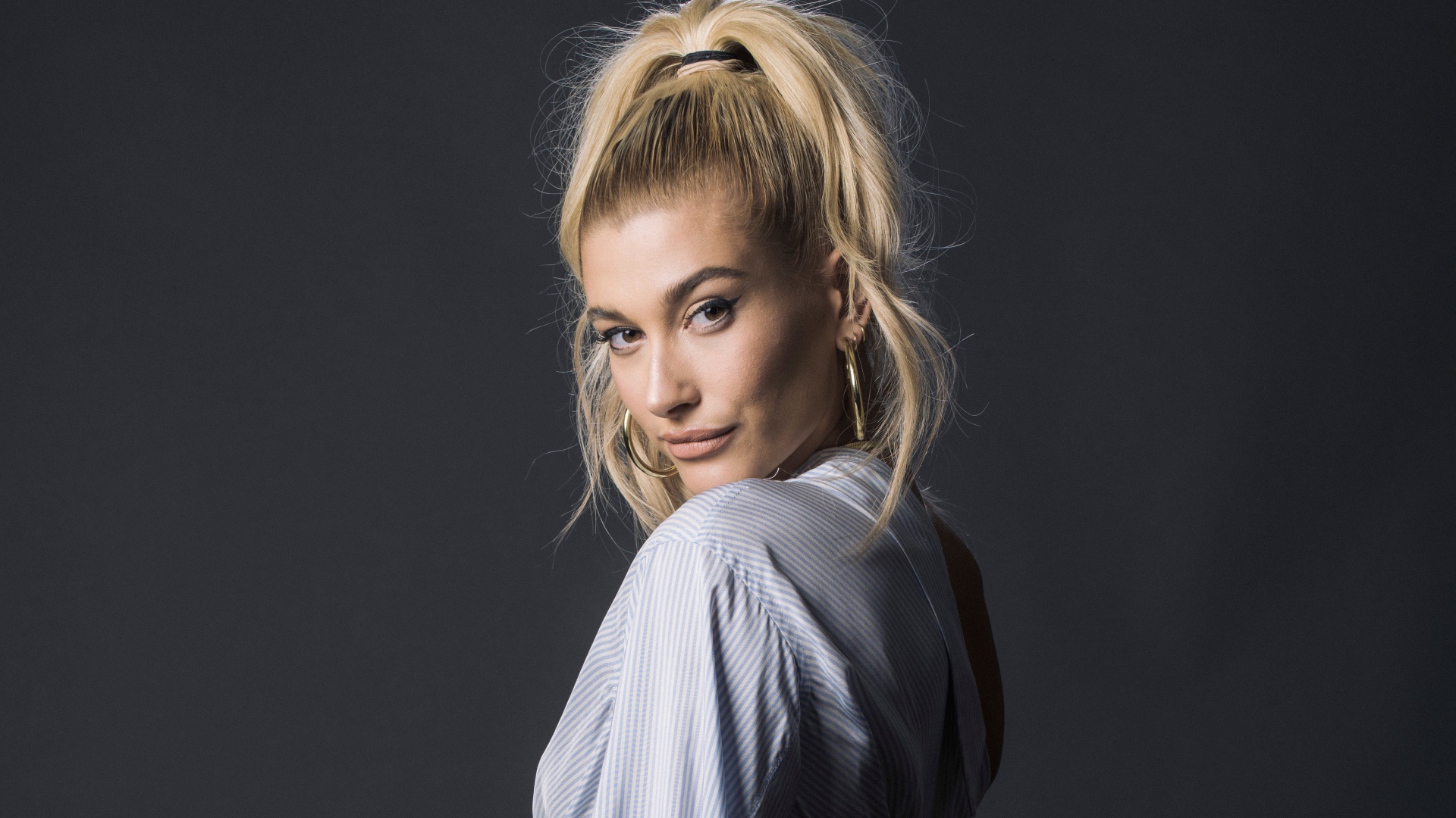 Красивая блондинка, американская модель Хейли Болдуин на сером фоне