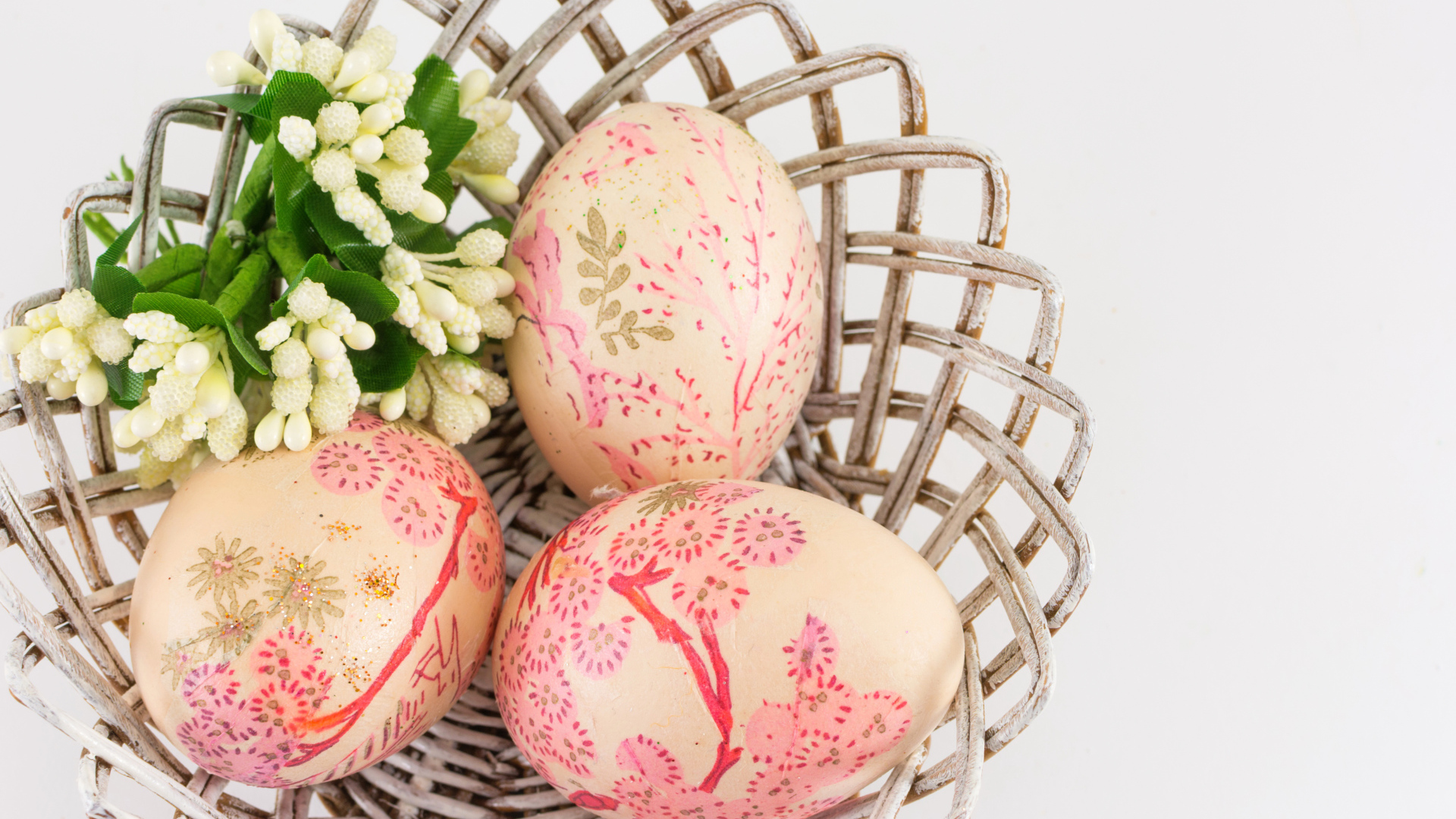 Яйца с рисунком в корзине с цветами на Пасху