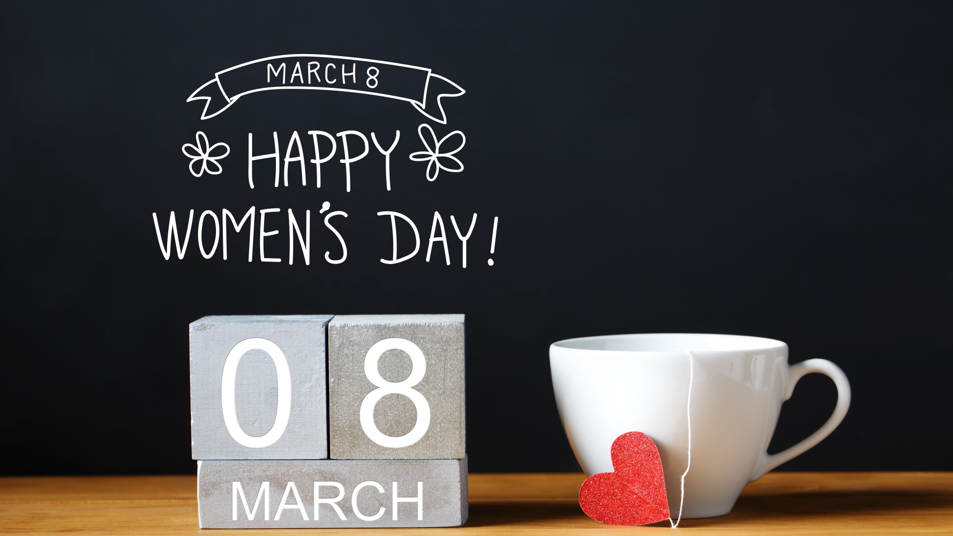 Чашка чая на столе с кубиками на Международный женский день 8 марта