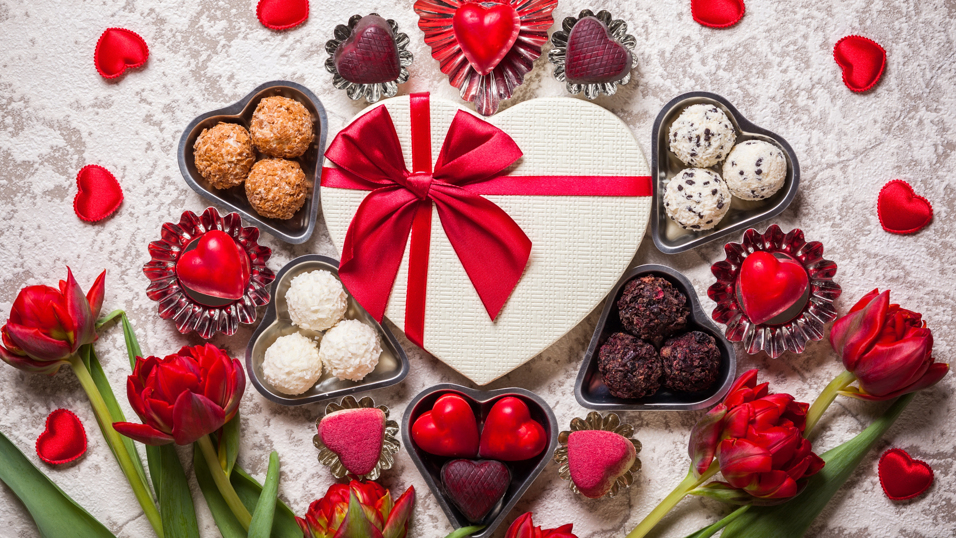 Конфеты и подарок на столе с букетом тюльпанов для любимой на 14 февраля