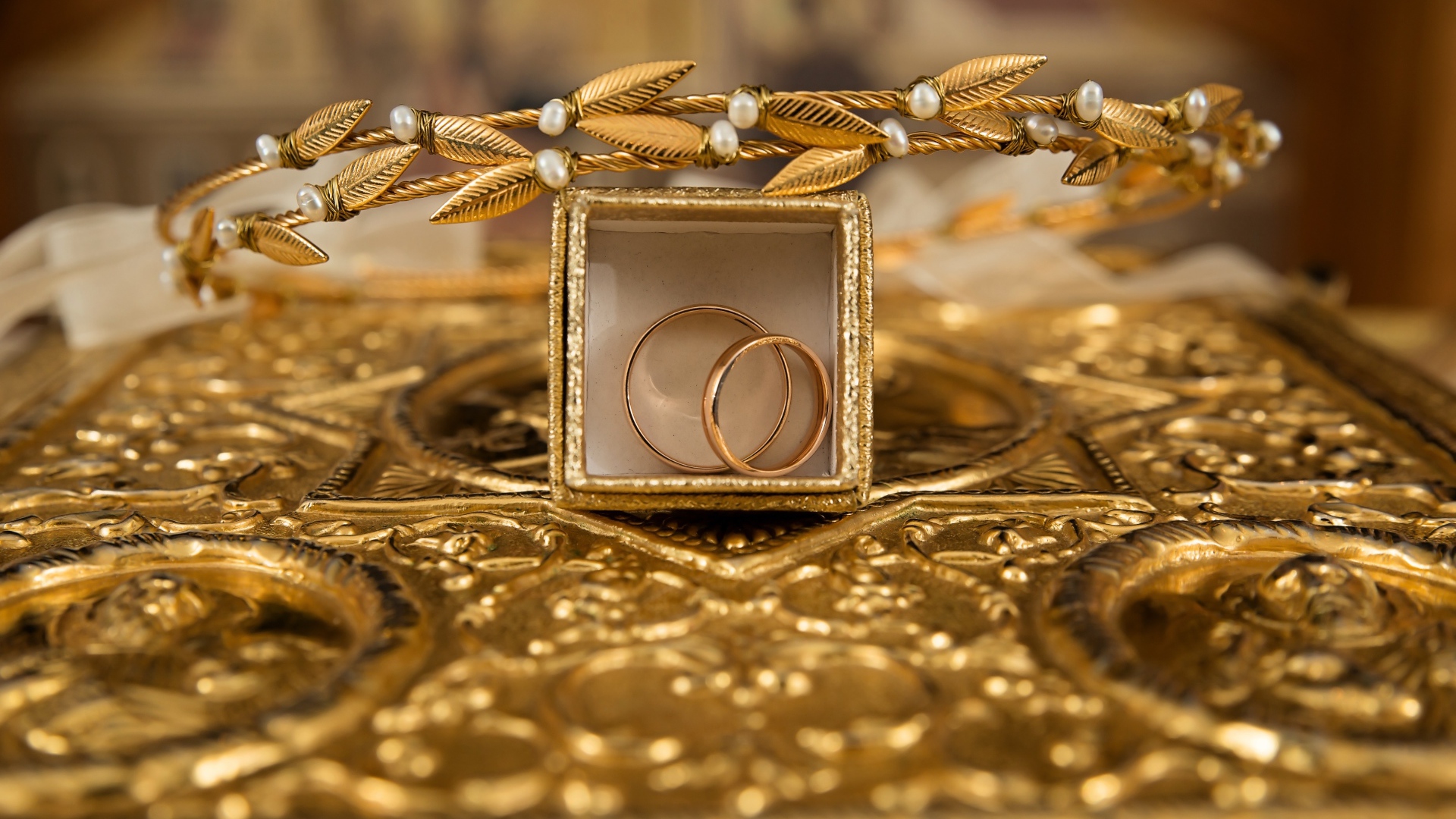 Два золотых обручальных кольца в коробке с венком 