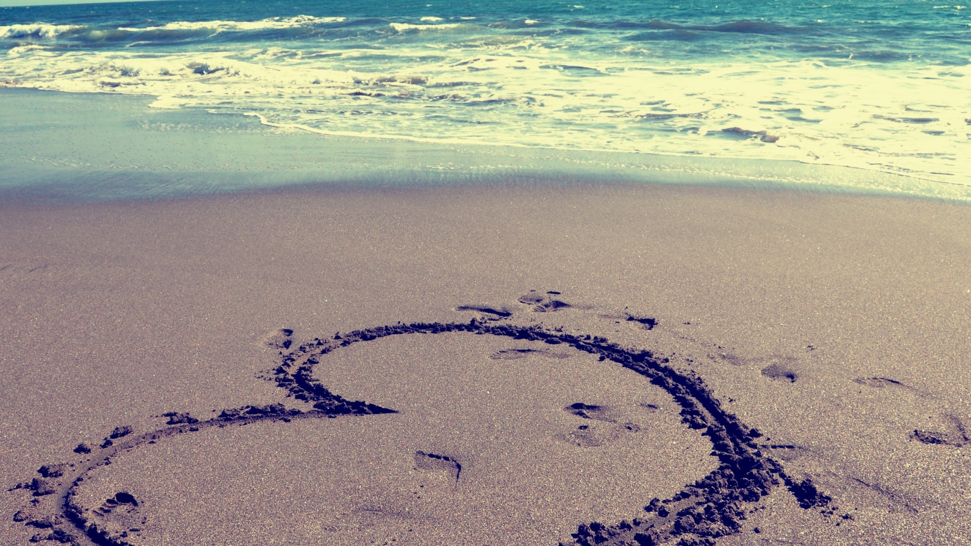 Большое сердце на мокром песке на пляже