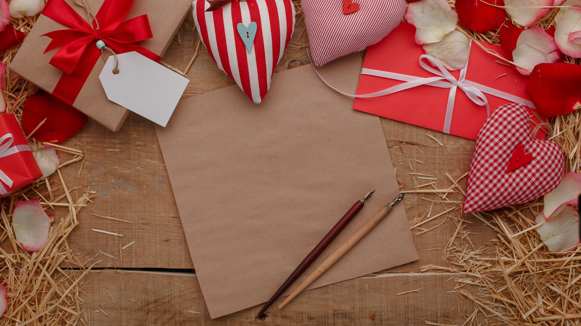 Сердечки из ткани на столе с бумагой и подарками 