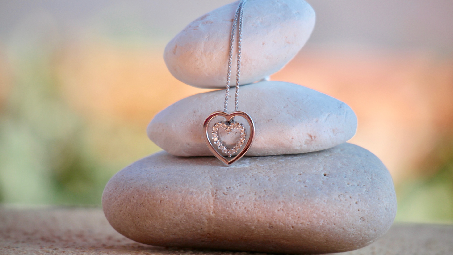 Heart shaped gold pendant hanging on stones