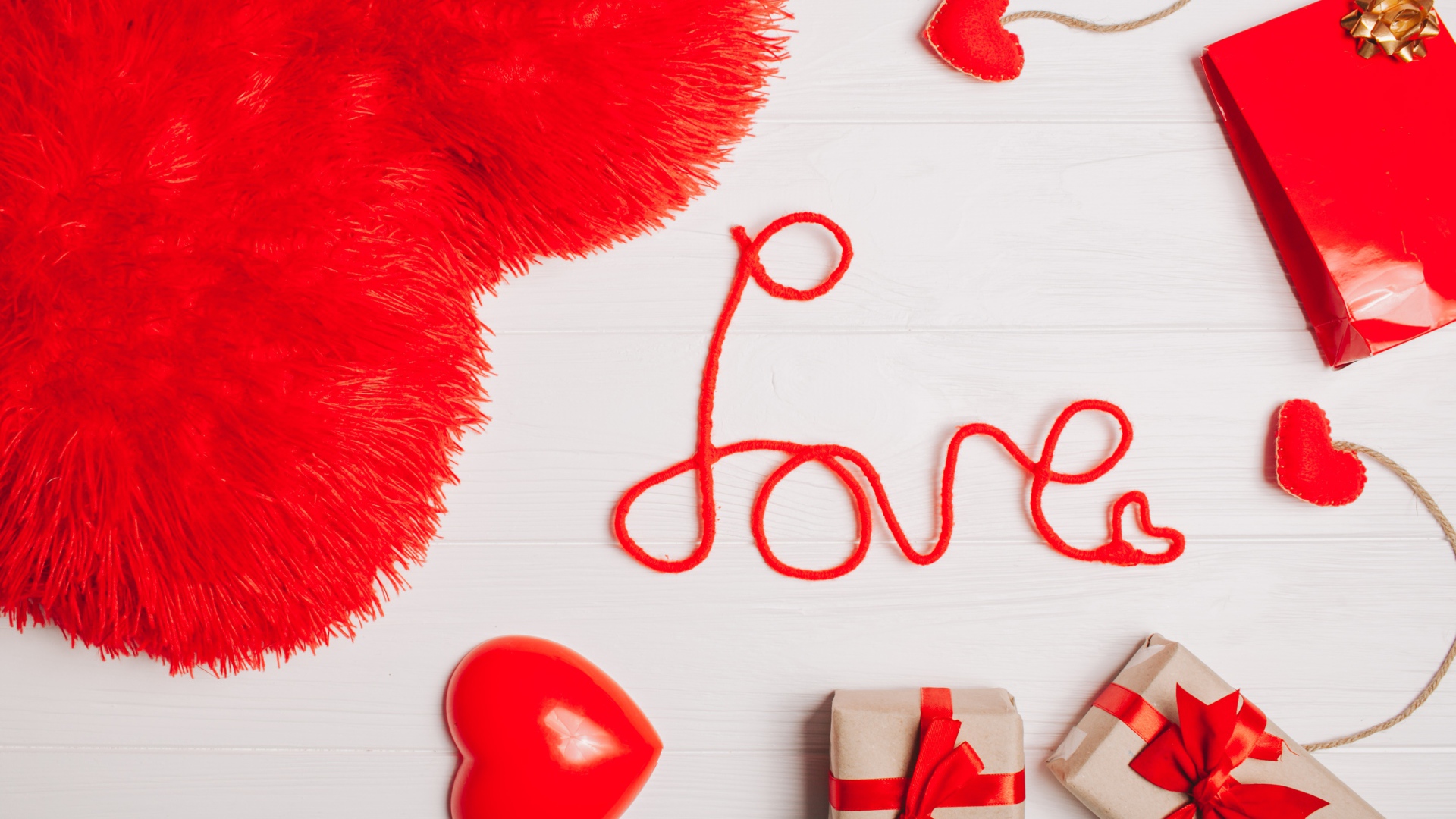 Большая подушка в форме сердца на столе с подарками 