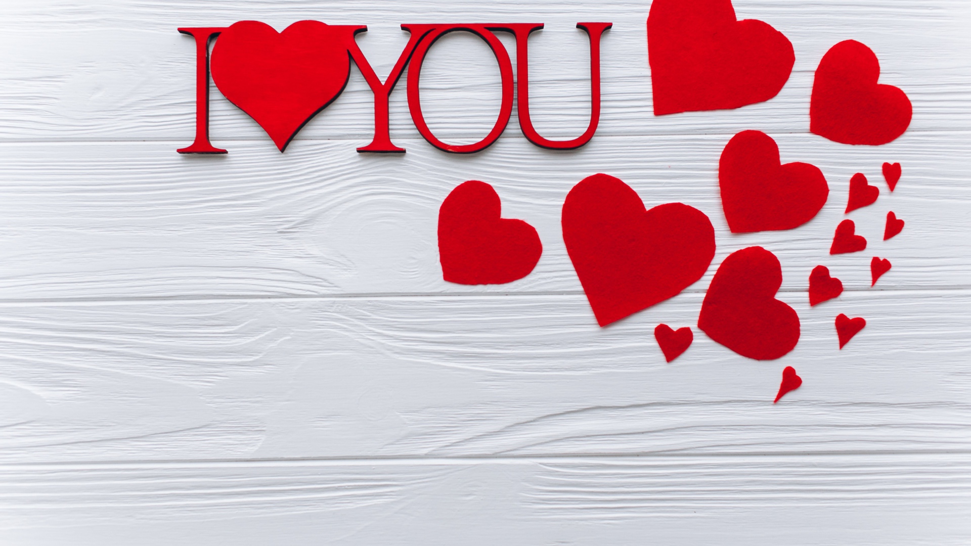 Надпись Я тебя люблю с красными сердечками на столе