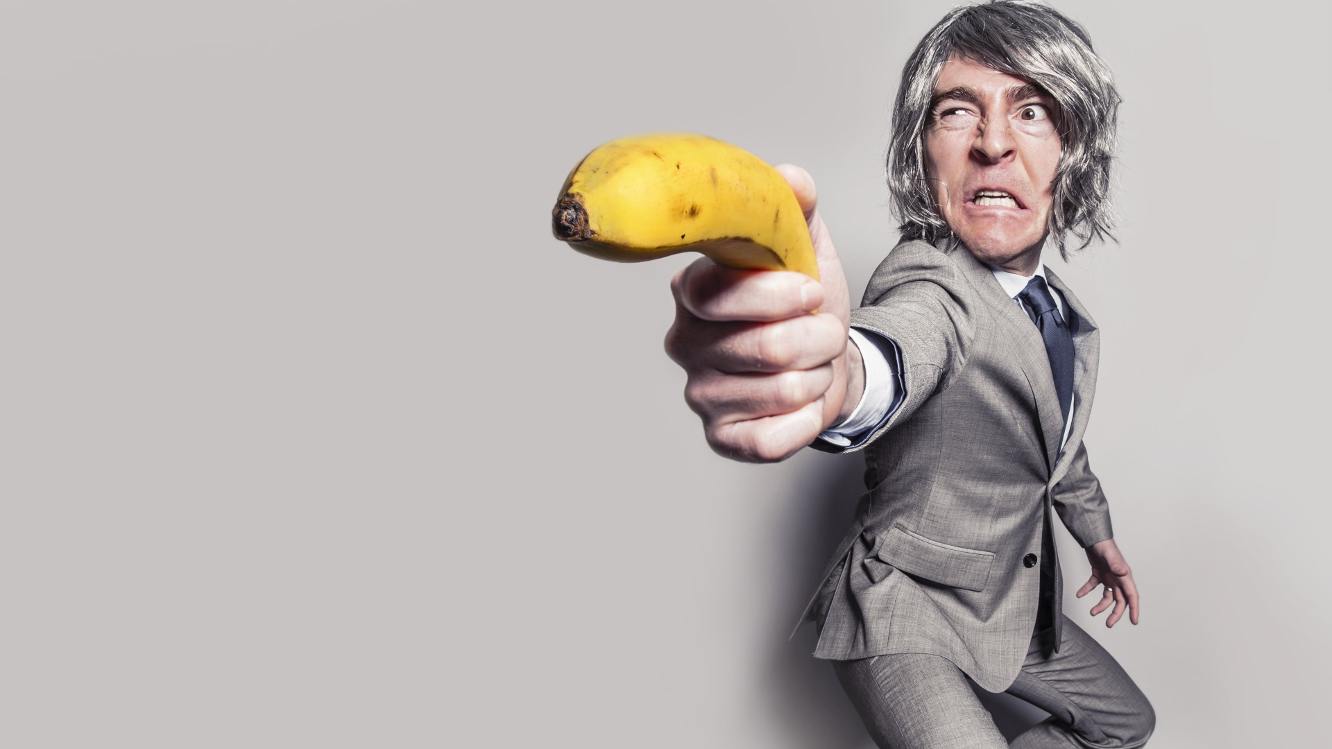 Мужчина в костюме защищается бананом