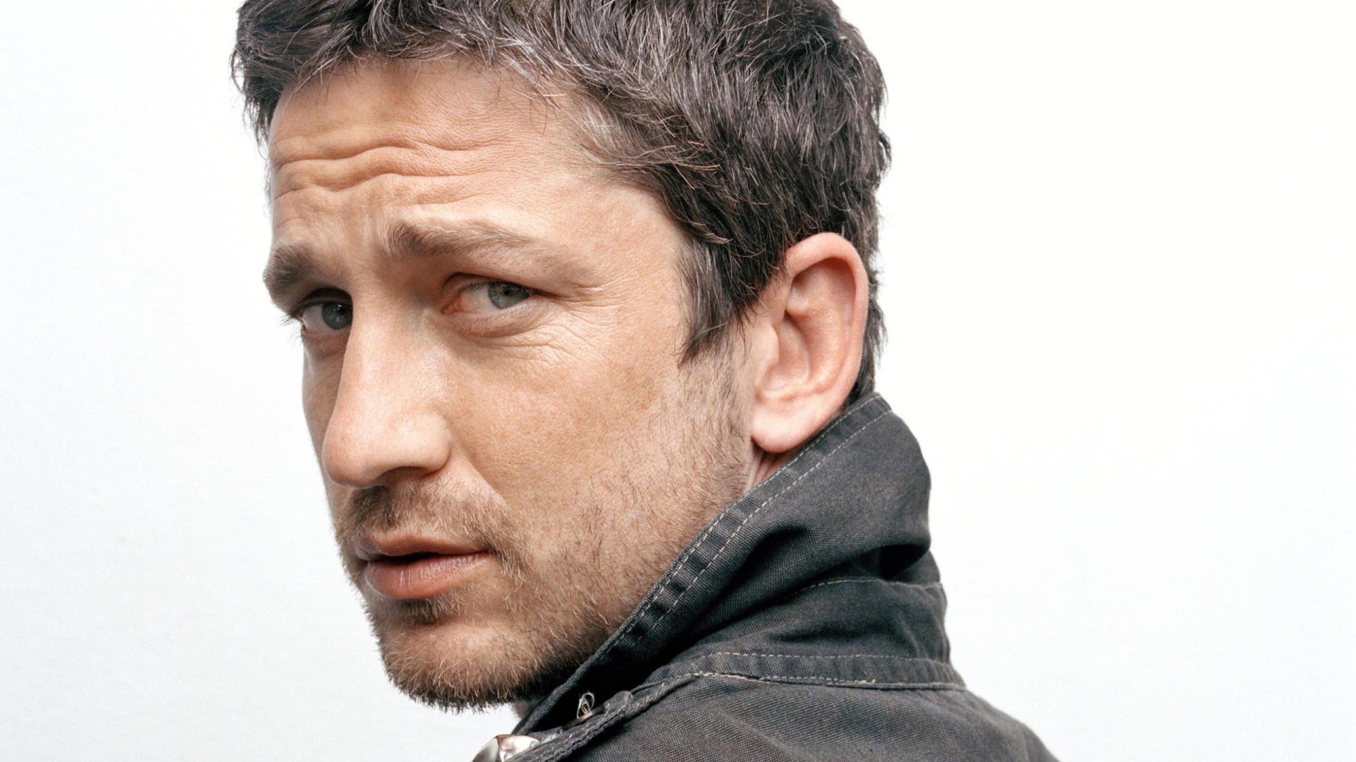 Актер Джерард Батлер крупным планом на белом фоне