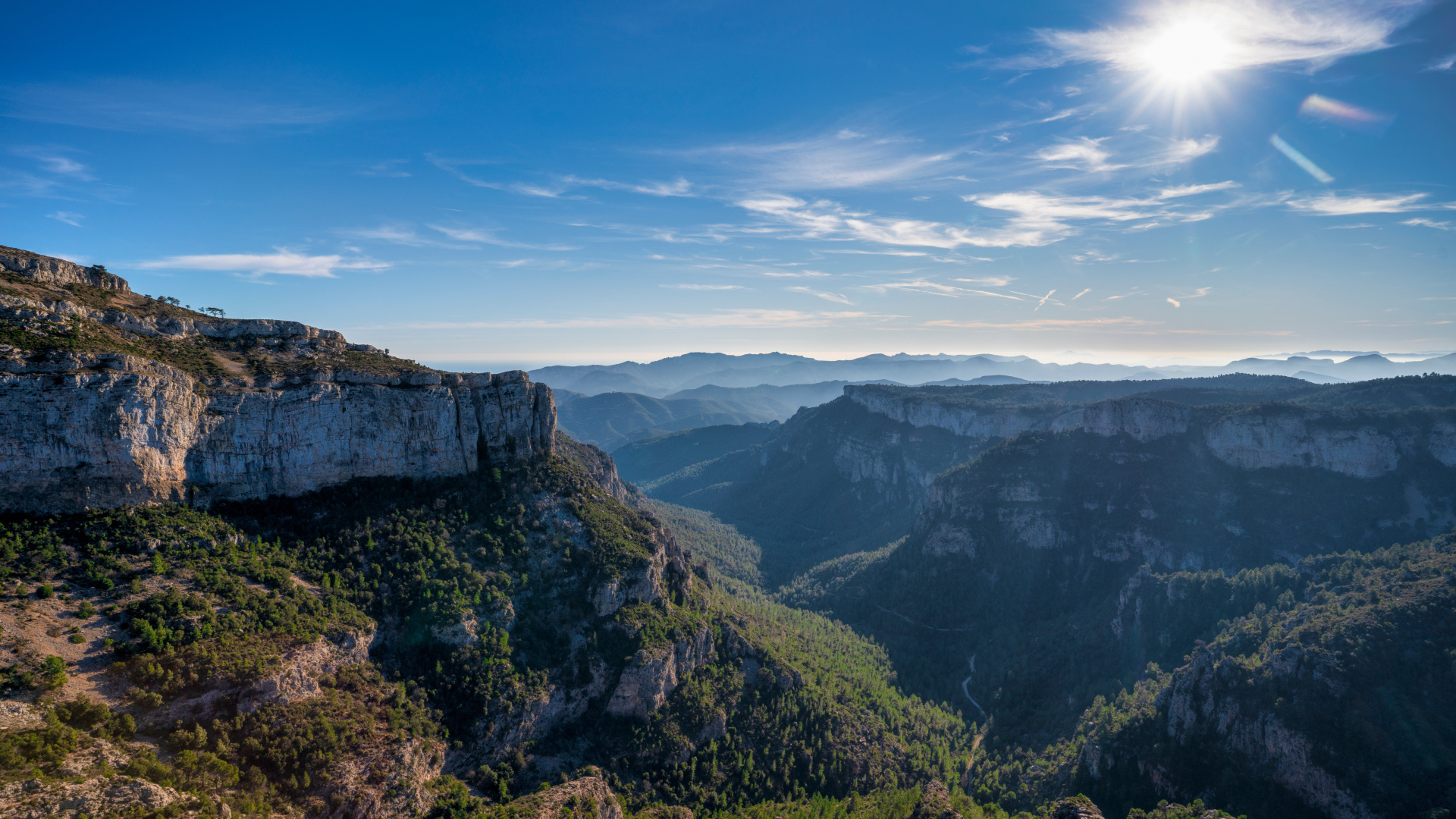 Яркое солнце в голубом небе над высокими горами 