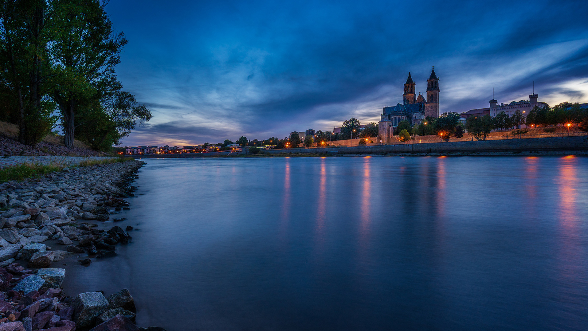 Замок у реки на фоне неба в сумерках 