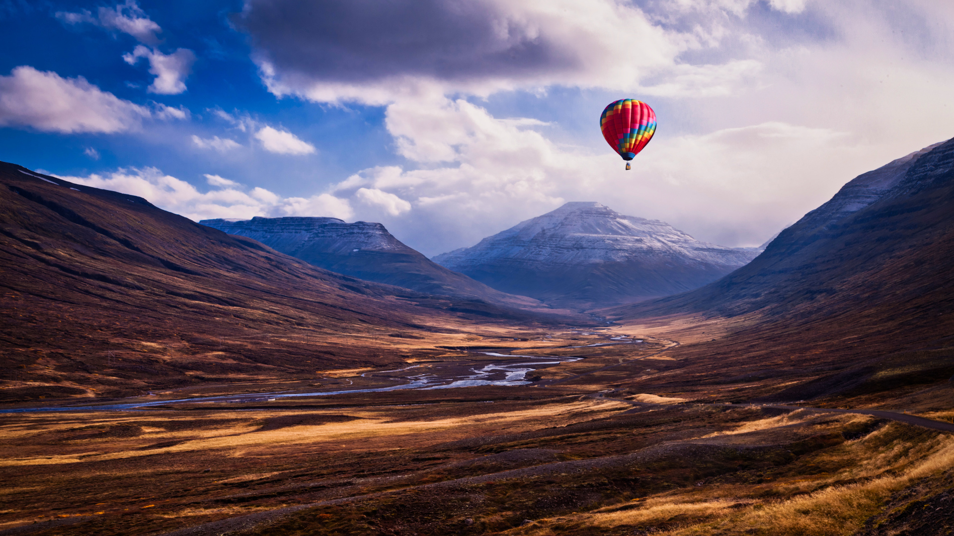 Разноцветный воздушный шар в небе над горами