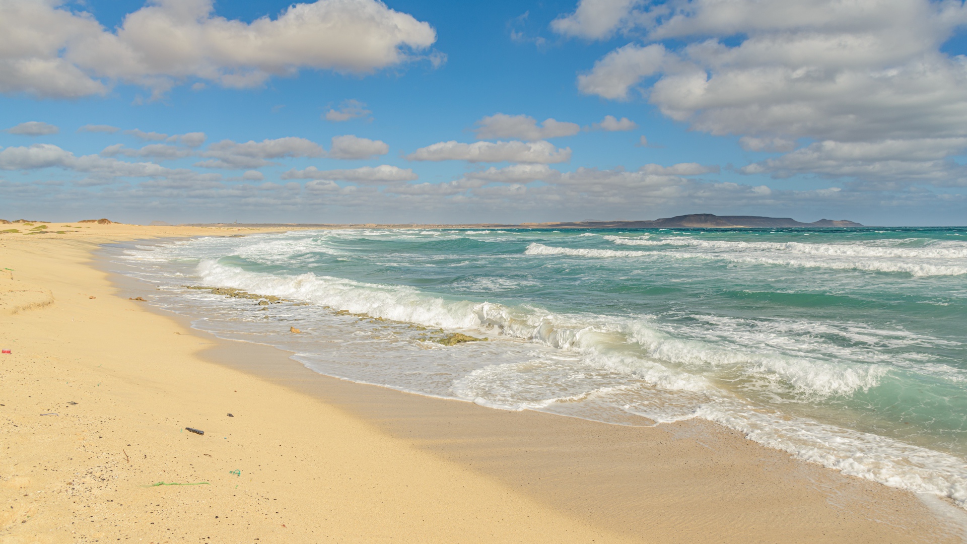 Бушующие морские волны на желтом горячем песке 