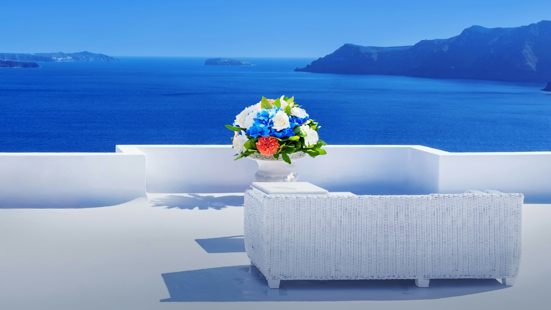 Красивый букет цветов на белом столе на фоне моря