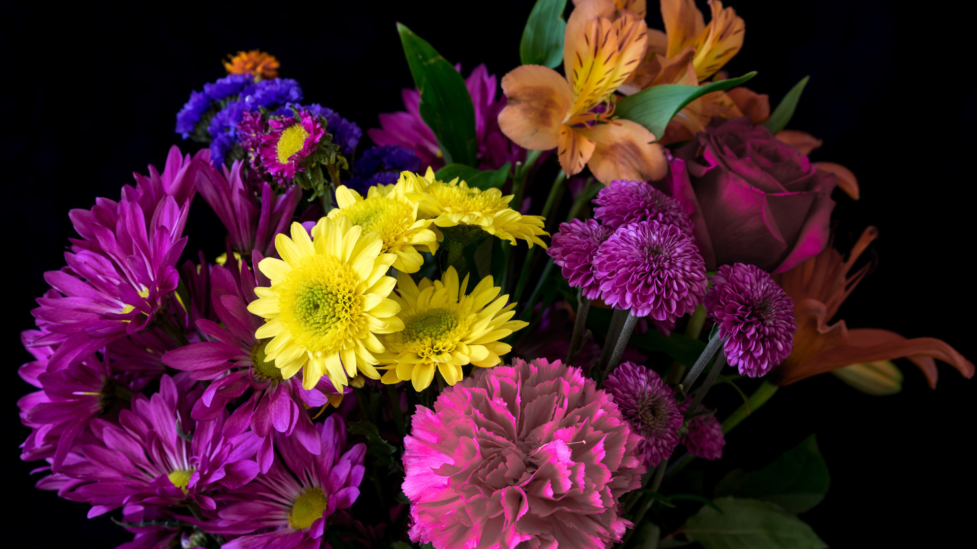 Букет разноцветных цветов на черном фоне крупным планом